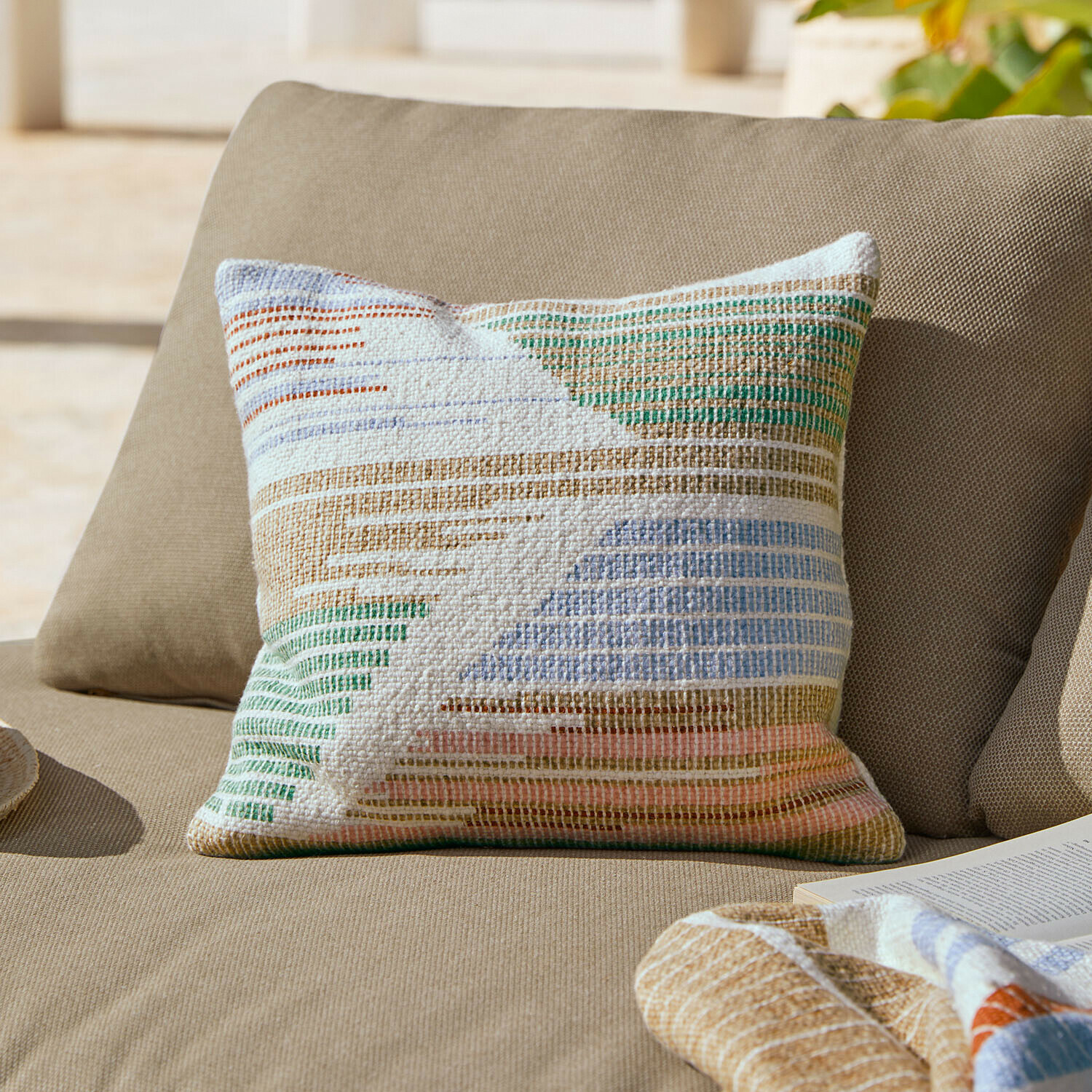 Bunte Baumwoll-Zierkissen mit geometrischem Muster auf beigem Sofa für Wohnzimmer