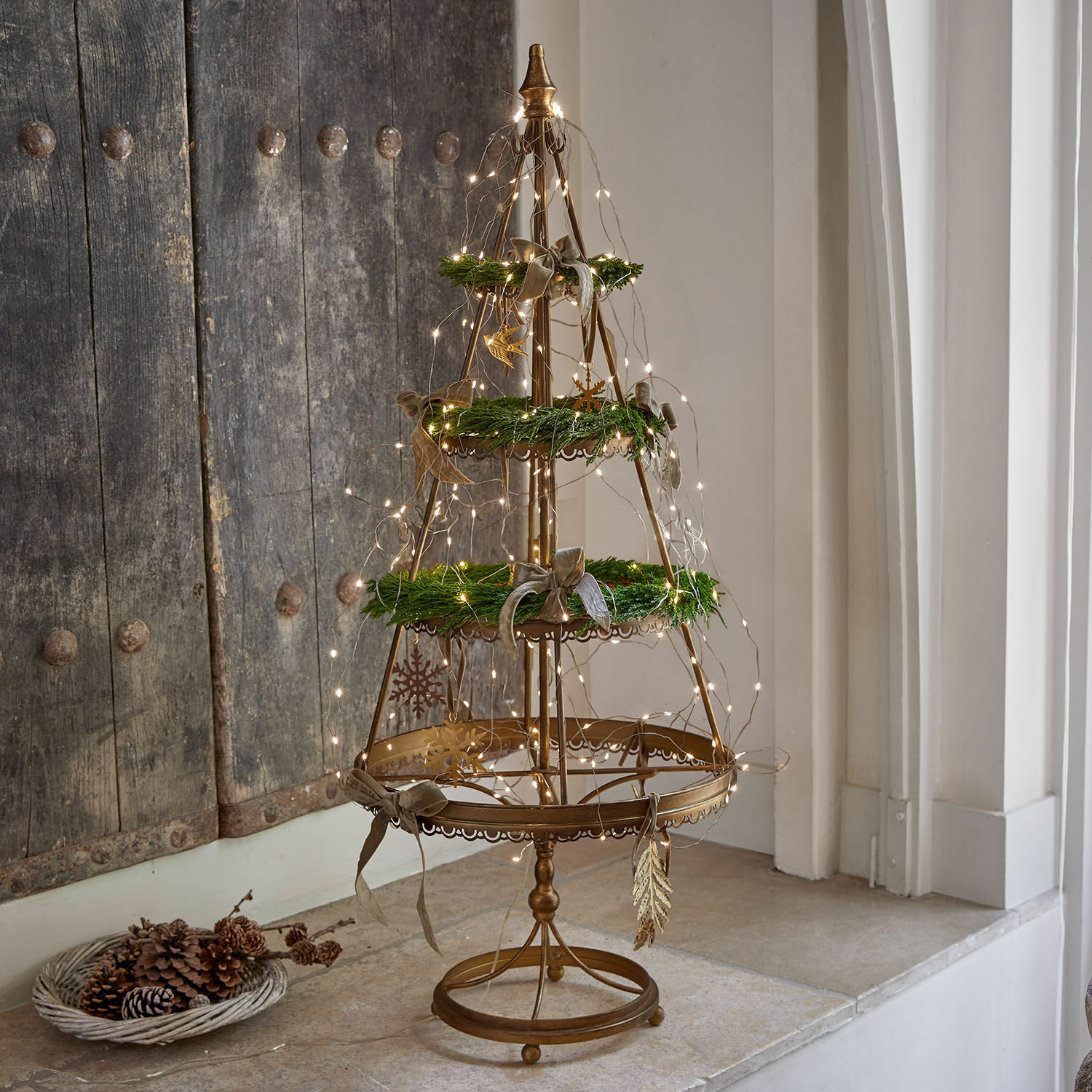 Deko-Baum Yolivine Goldfarbene Metall-Weihnachtsdekoration mit grünen Kränzen und LED-Lichterkette auf Tisch
