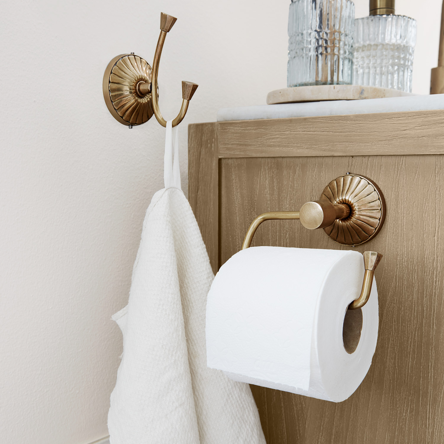 Messing Toilettenpapierhalter und Doppelhaken mit weißem Handtuch im Badezimmer