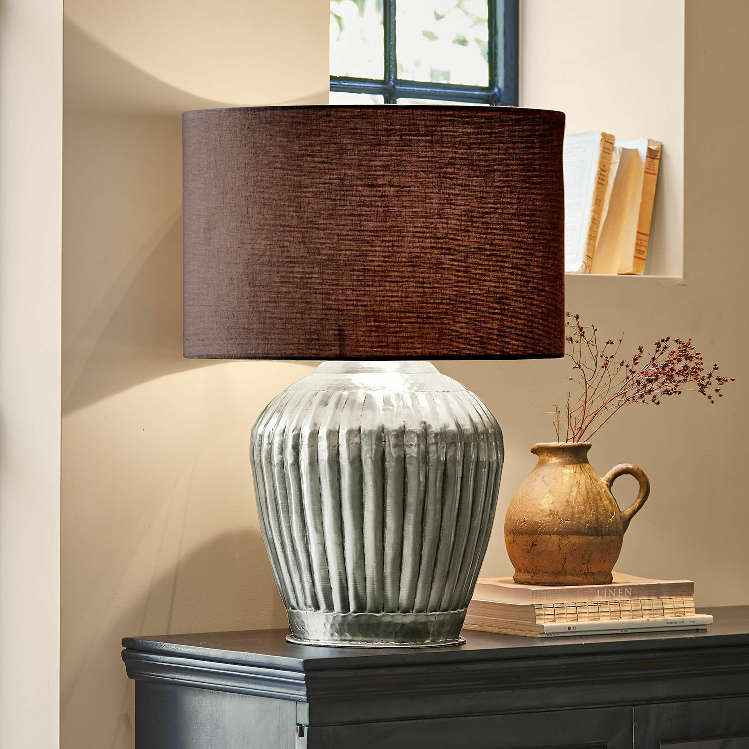 Tischlampe Fauville Tischlampe mit silberner Metallbasis und braunem Lampenschirm auf dunklem Sideboard