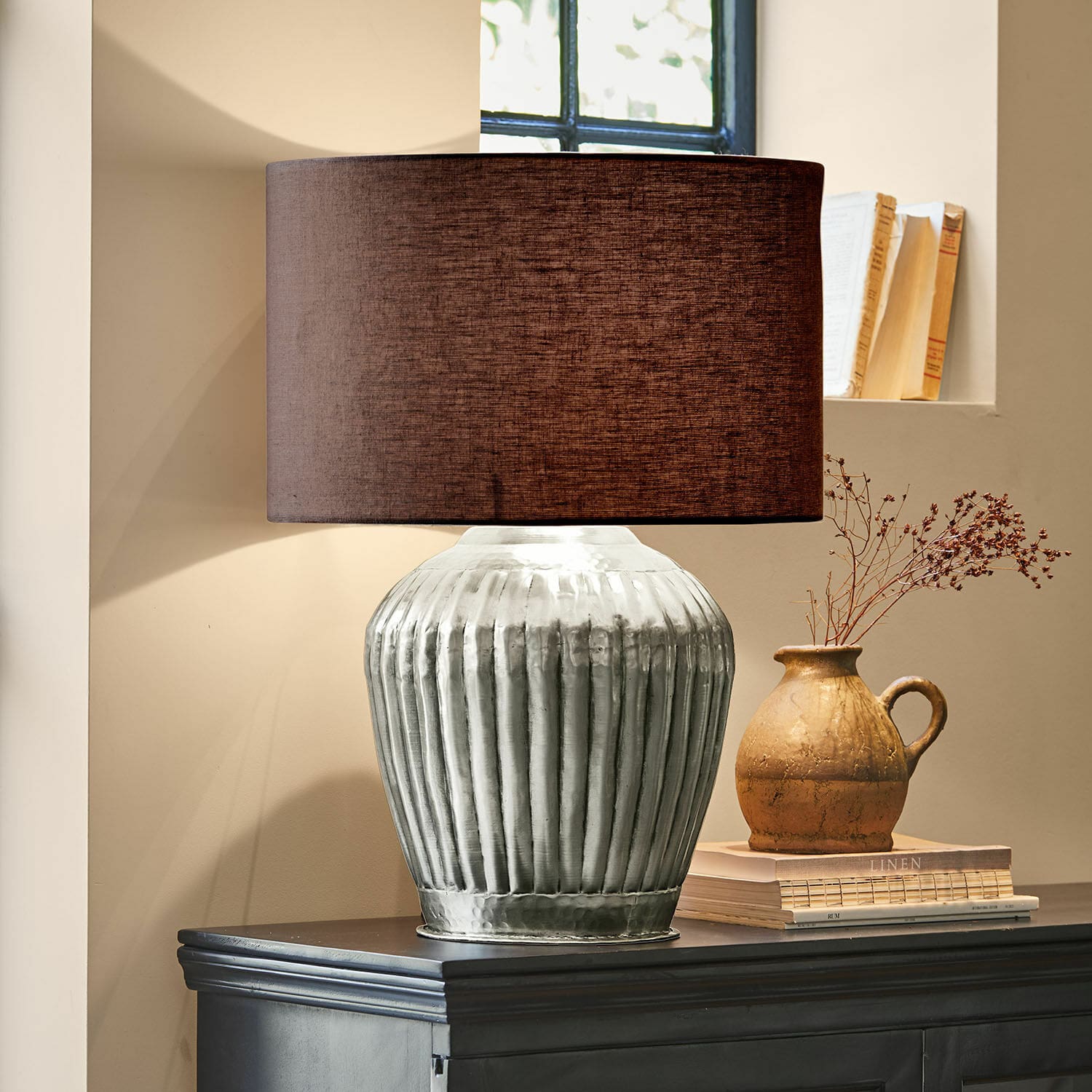 Tischlampe Fauville Tischlampe mit silberner Metallbasis und braunem Lampenschirm auf dunklem Sideboard