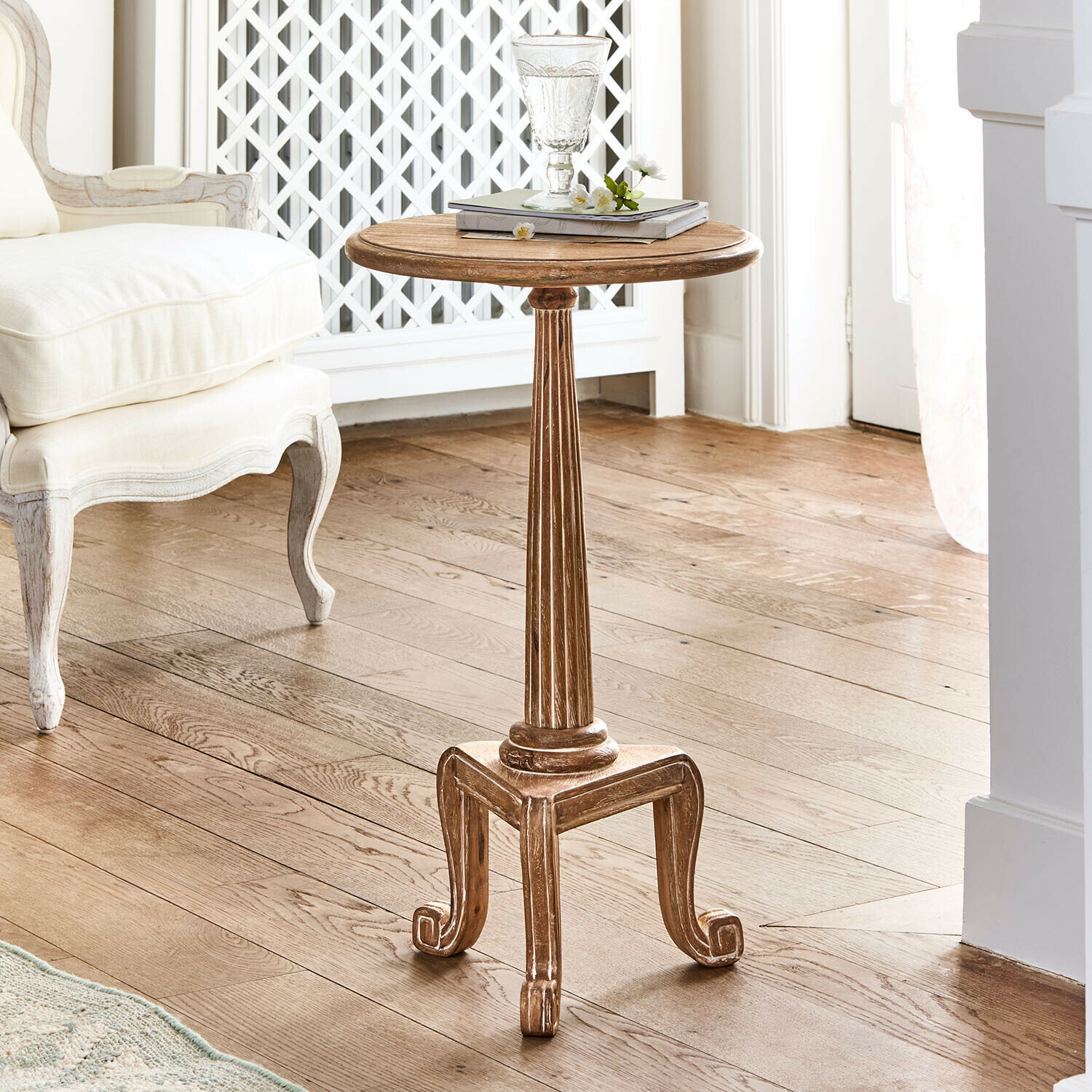 Runder Beistelltisch aus Holz in Naturfarbe mit verzierten Beinen im Vintage-Stil im Wohnzimmer