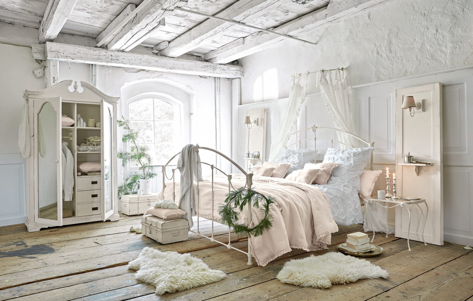 Shabby-Chic Schlafzimmer mit weißem Metallbett und pastellfarbener Bettwäsche auf Holzdielen