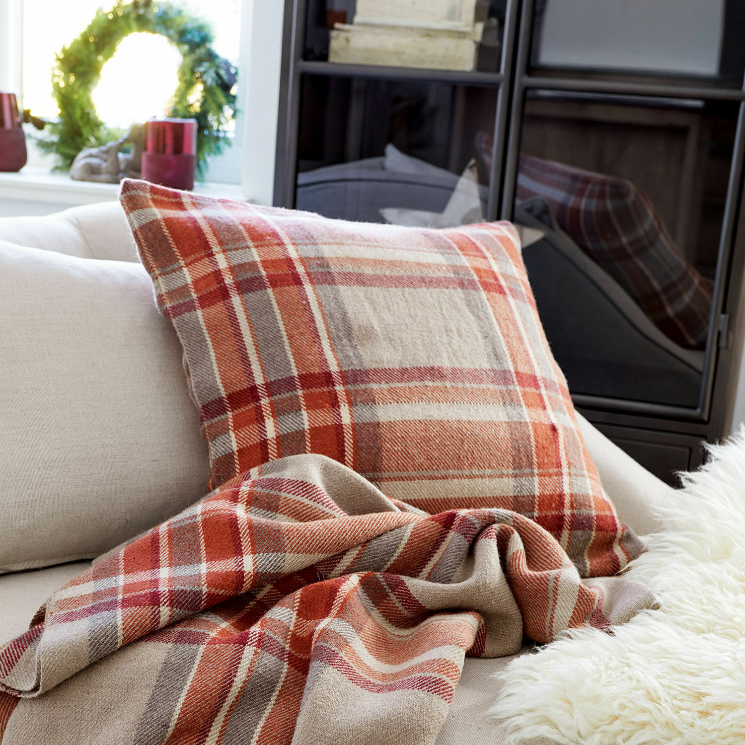 Kissenhülle Tartan Warme Kissen und Plaid in Rot- und Beigetönen kariert auf hellem Sofa im Wohnzimmer