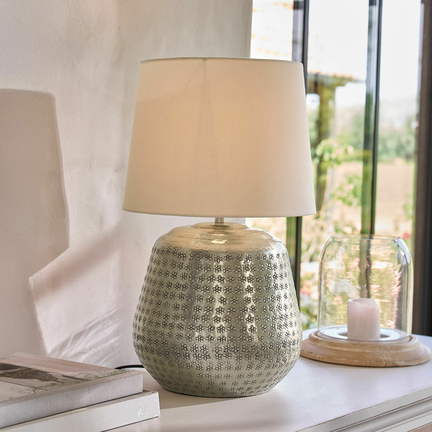 Tischlampe mit silberner Metallbasis und Muster sowie cremefarbenem Lampenschirm, Wohnaccessoire