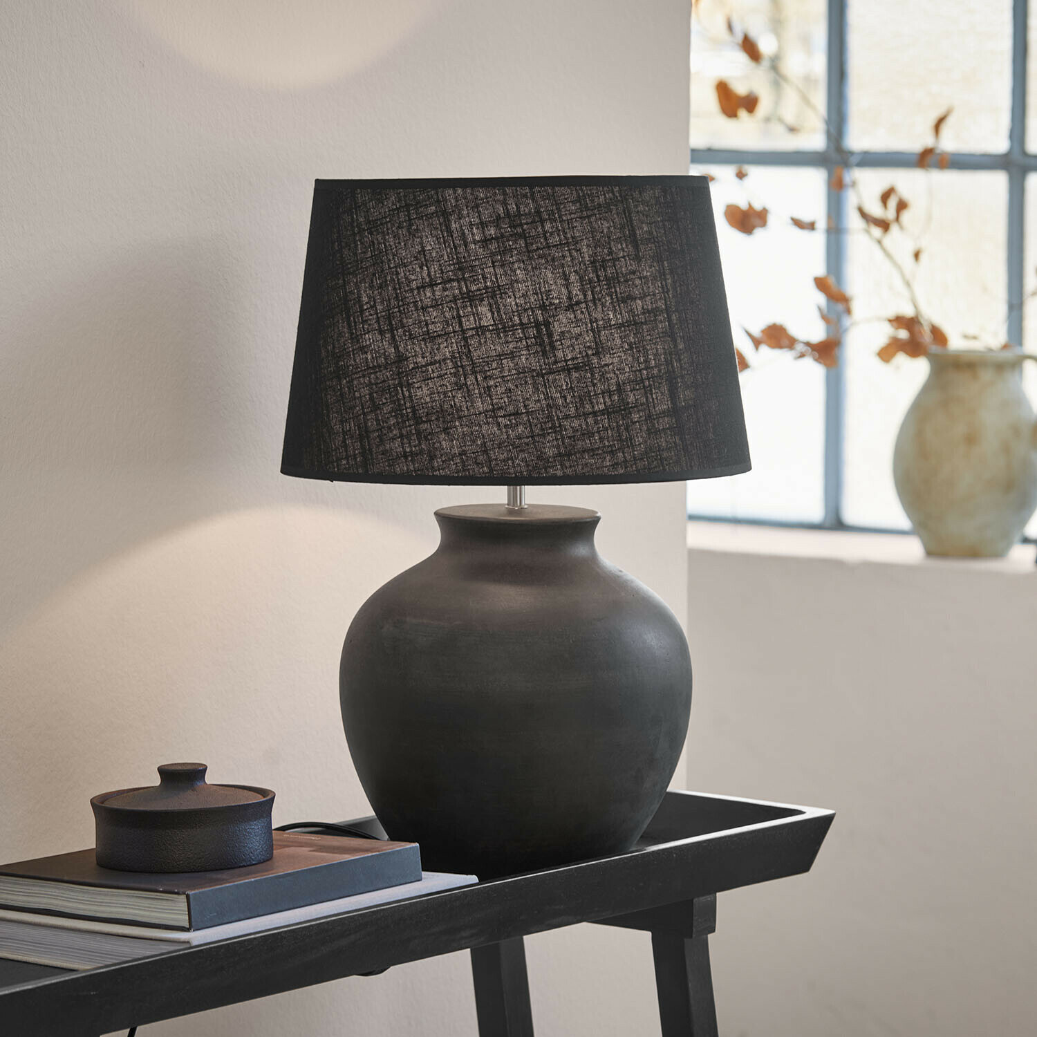 Tischlampe Branver Schwarze Keramik-Tischlampe mit Stoffschirm auf Tisch mit Büchern und Dekoration