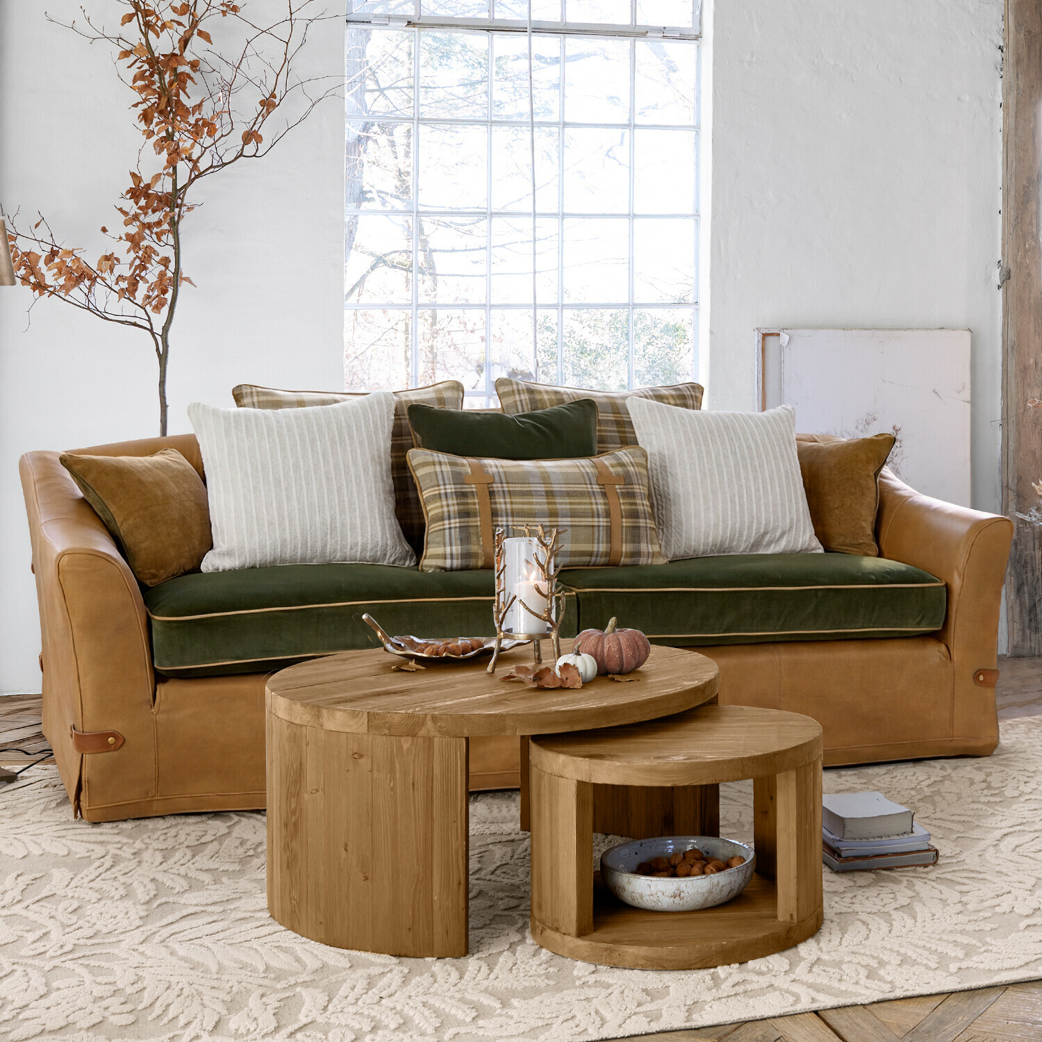 Sofa Halton Ledersofa in Braun mit grünem Samtkissen und karierten sowie gestreiften Kissen im hellen Wohnzimmer