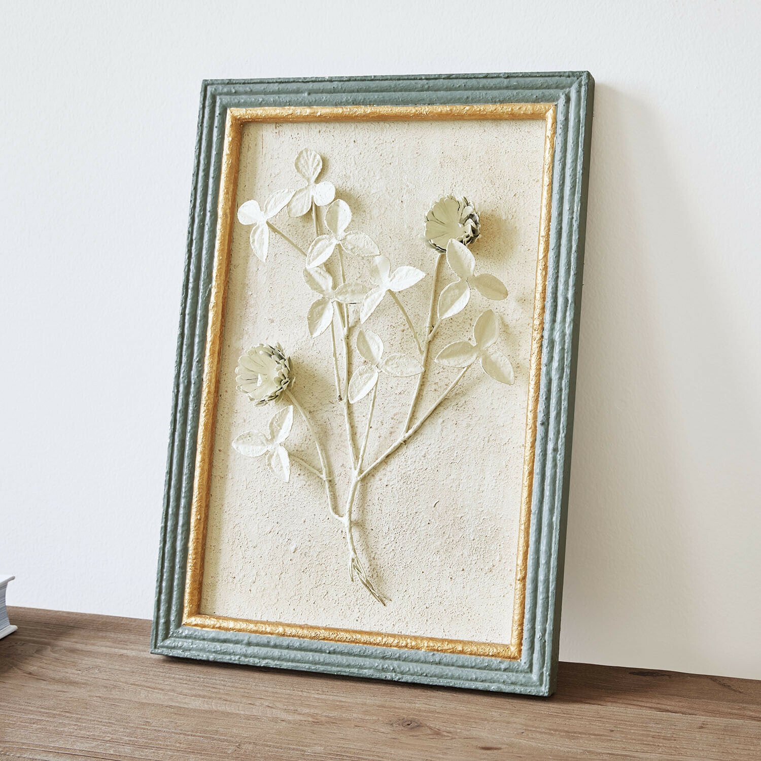 Bild Rivolenne Dekoratives Bild mit Blumenrelief in grün-goldenem Rahmen auf Holztisch stehend