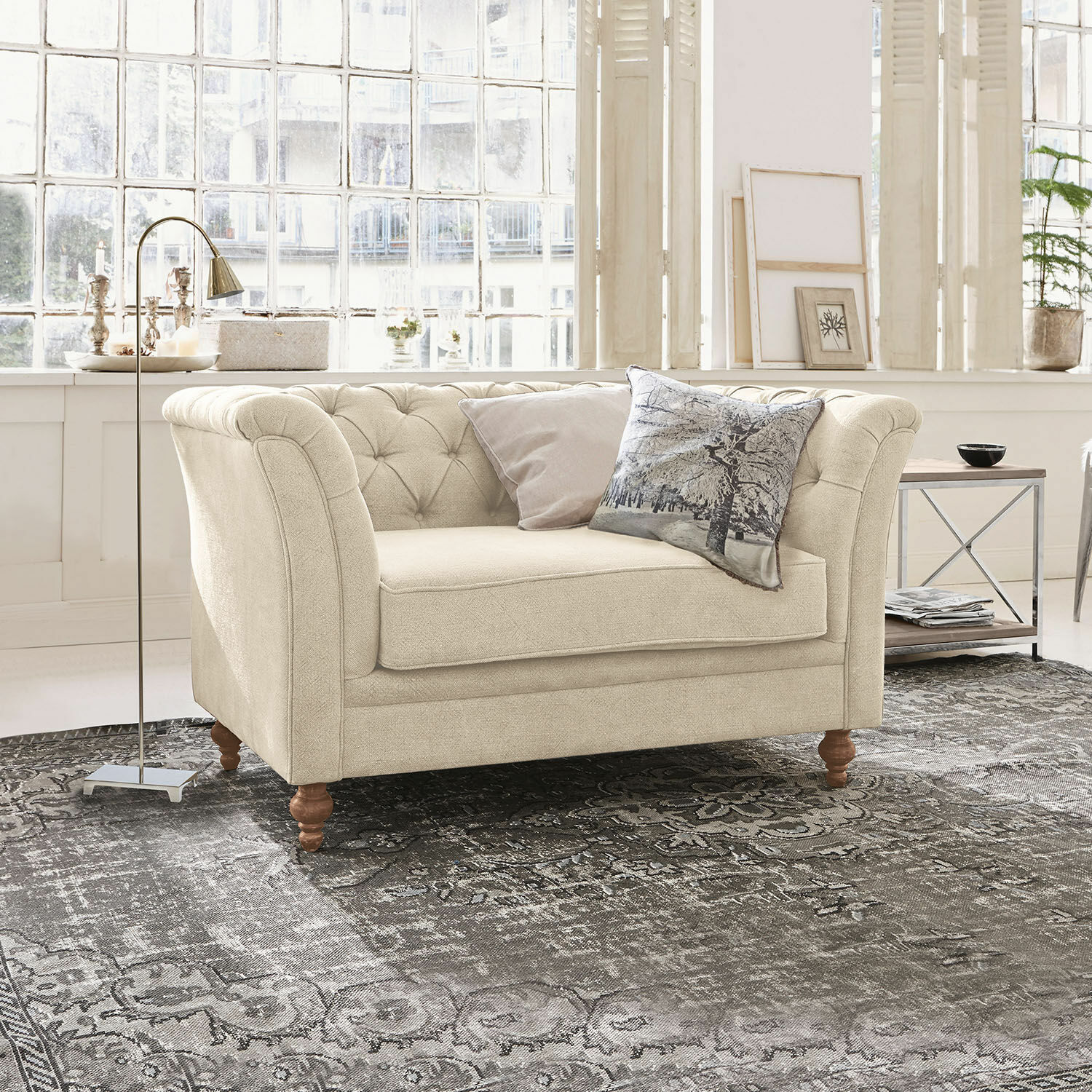 Sofa Clères Beiges Stoffsofa mit gesteppter Rückenlehne und Holzbeinen auf grauem Teppich in hellem Raum