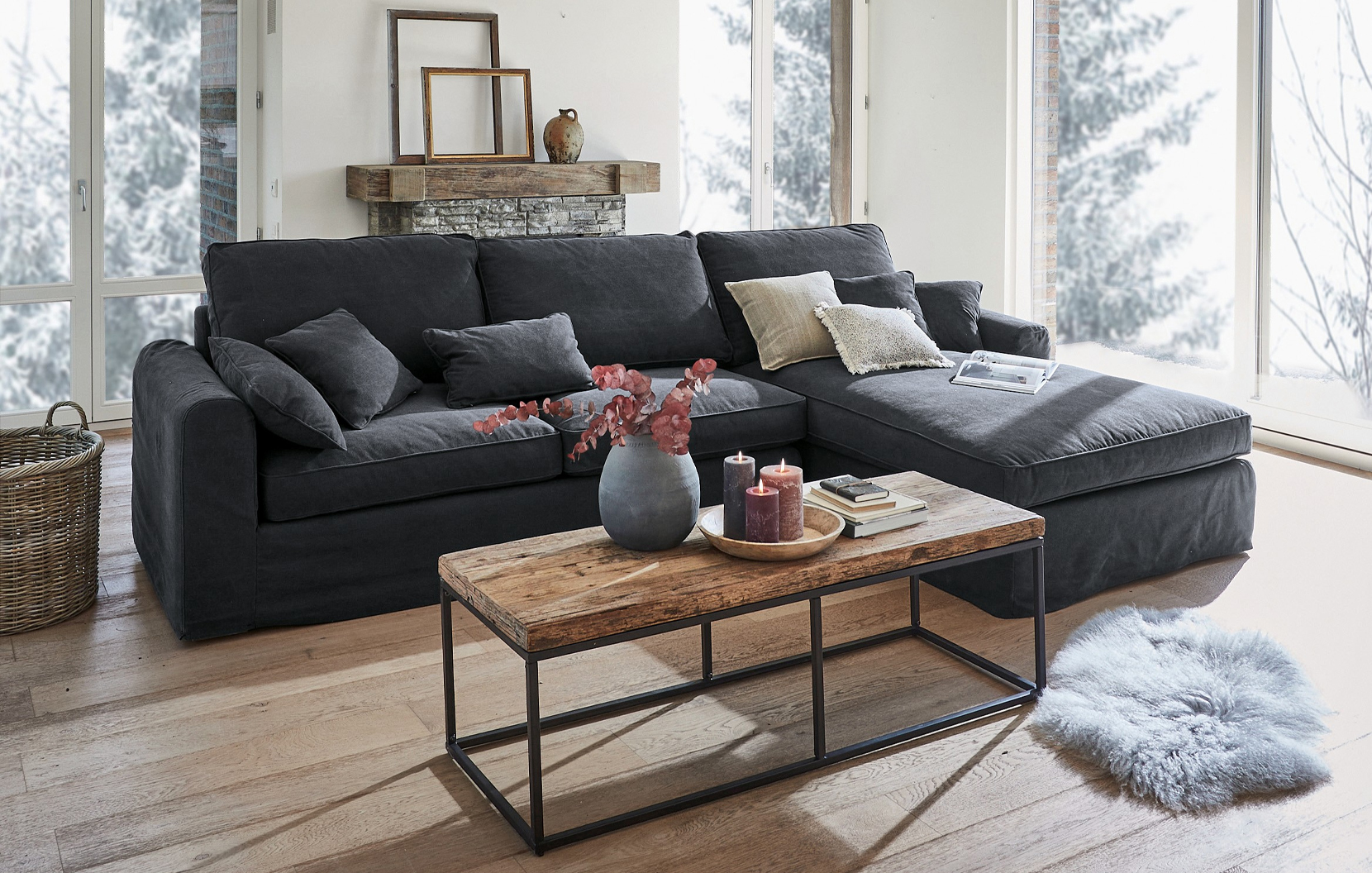 Graues Ecksofa aus Stoff im Industrial-Stil mit Holztisch und Dekorationen in hellem Wohnzimmer