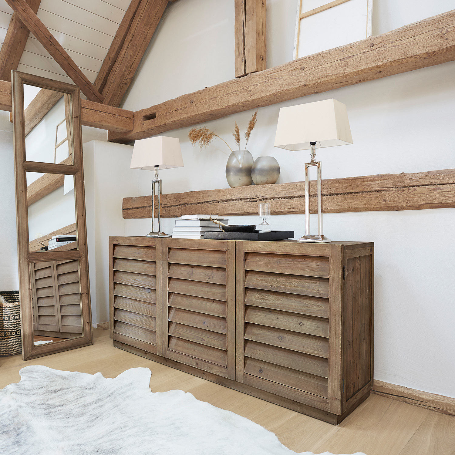Kommode Lens Rustikale Holzkommode mit Lamellentüren in Naturfarbe, dekoriert mit Tischlampen und Vasen im Wohnraum