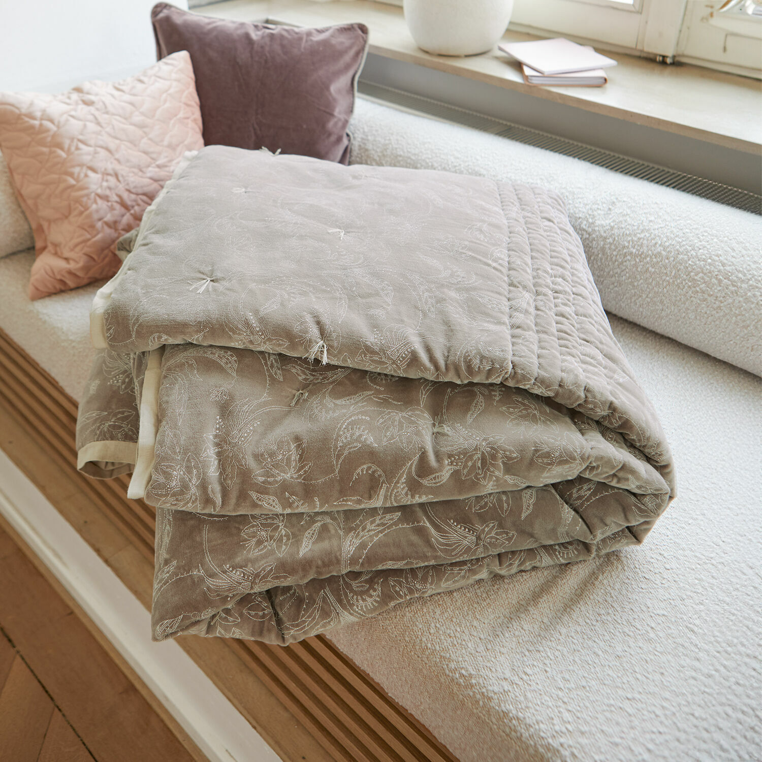 Quilt Olicianne Beige gesteppte Tagesdecke mit zartem Blumenmuster auf hellem Sofa im Wohnzimmer