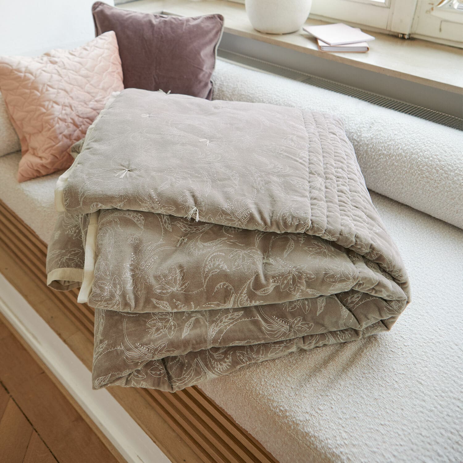 Quilt Olicianne Beige gesteppte Tagesdecke mit zartem Blumenmuster auf hellem Sofa im Wohnzimmer