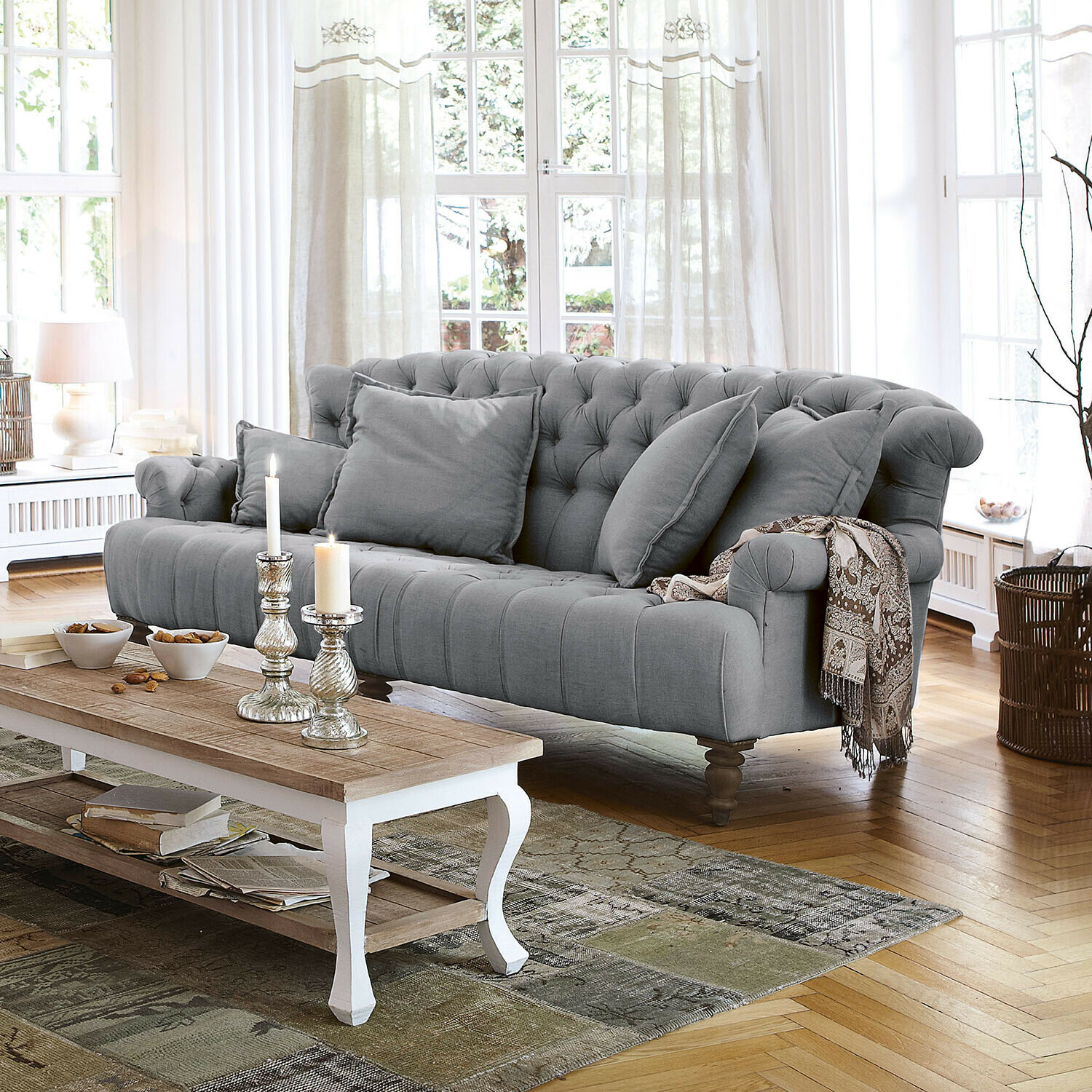 Sofa Springfield Village Grau gepolstertes Sofa aus Stoff mit Kissen und dekorativer Decke im hellen Wohnzimmer