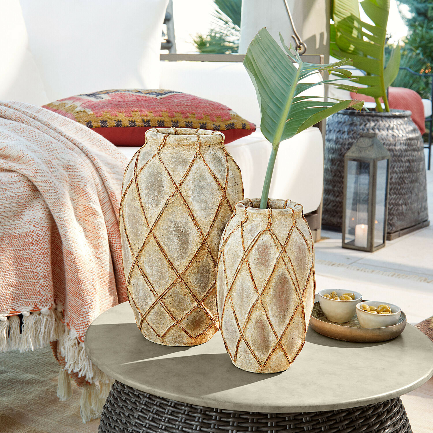 Vase 2er Set Deloriva Zwei beige Keramikvasen mit geometrischem Muster auf einem Rattantisch im Außenbereich