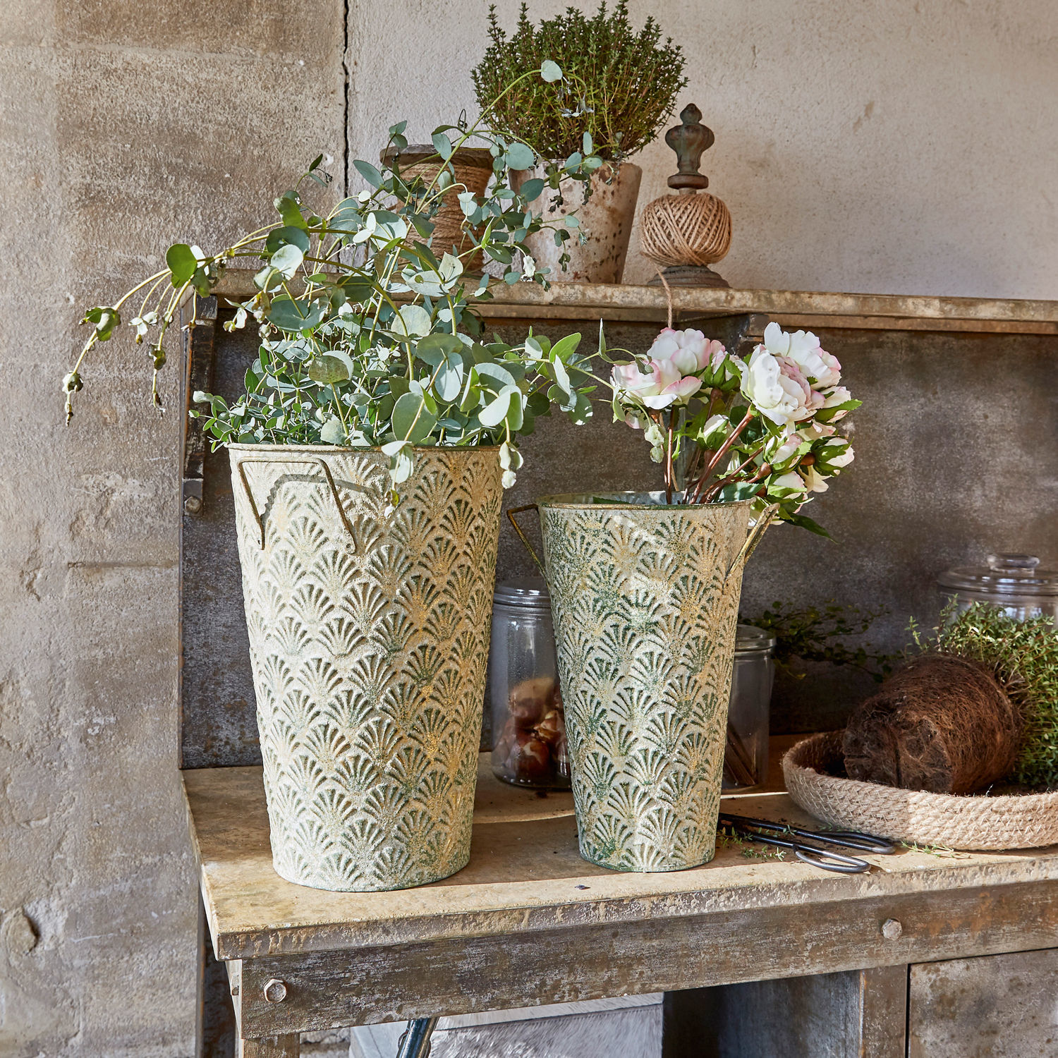 Deko-Vase 2er Set Iskele Zwei dekorative Metallblumentöpfe in Grün-Beige mit Pflanzen auf rustikalem Holztisch