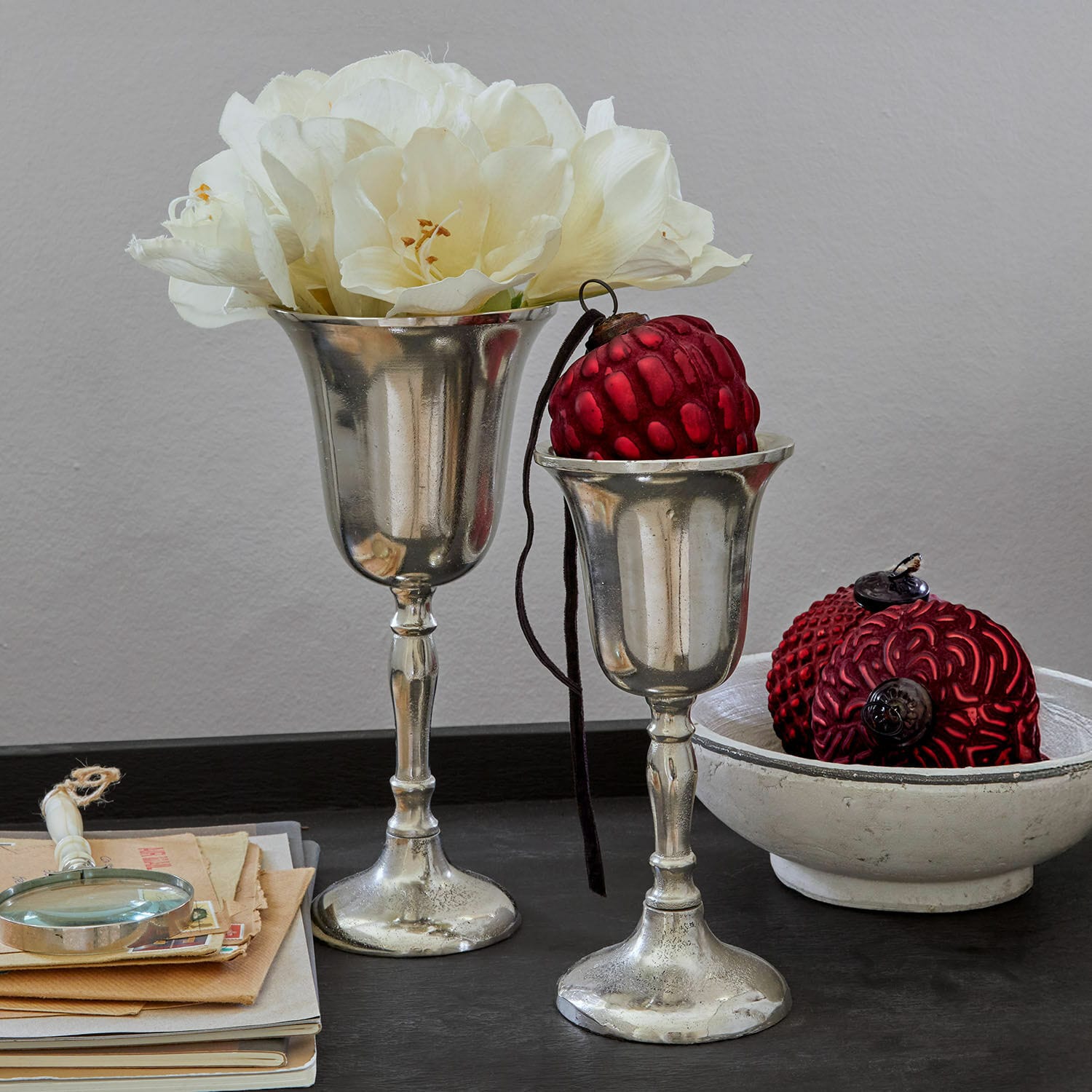 Vase 2er Set Solérie Zwei silberne Dekokelche mit weißen Blumen und roten Ornamenten auf schwarzem Tisch