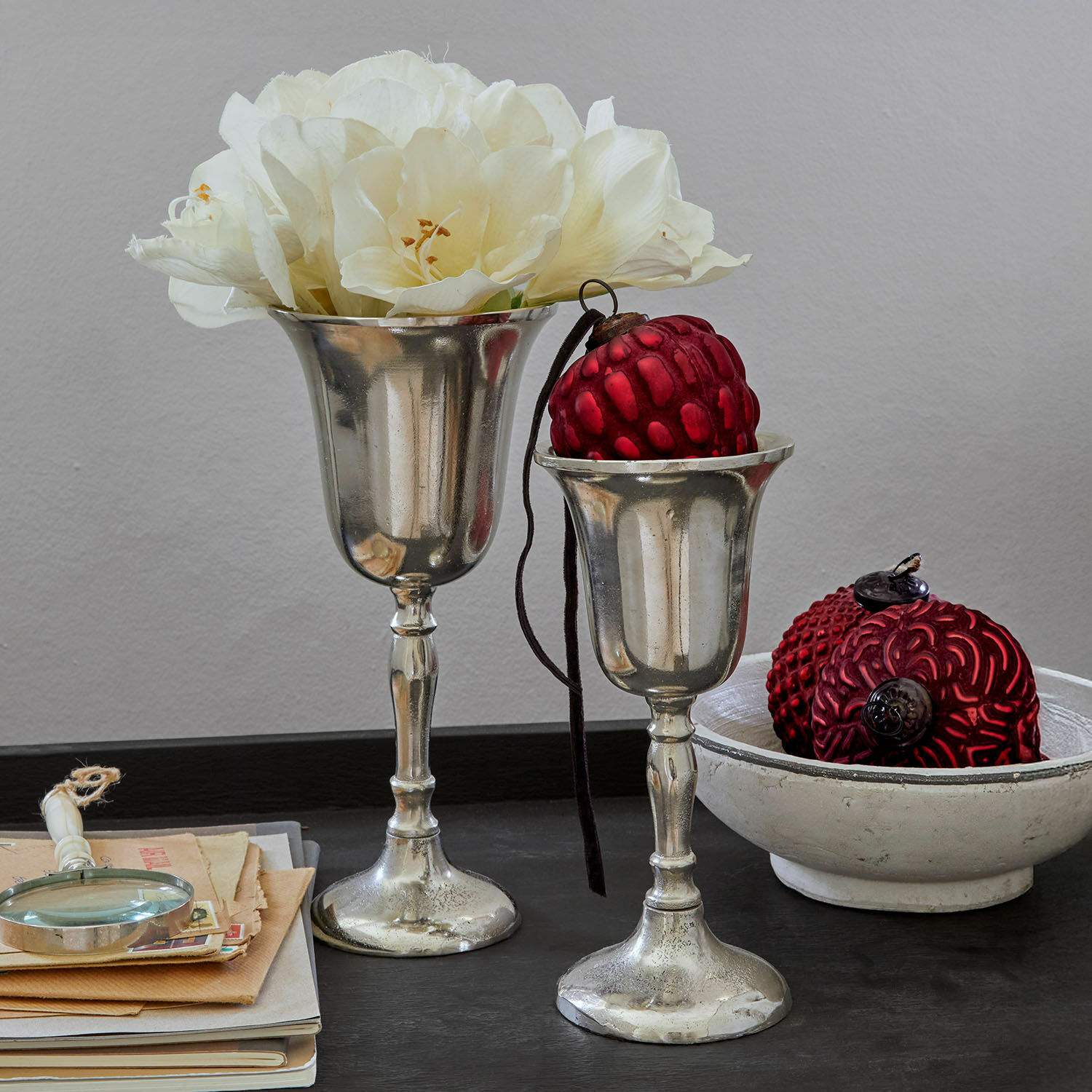Vase 2er Set Solérie Zwei silberne Dekokelche mit weißen Blumen und roten Ornamenten auf schwarzem Tisch