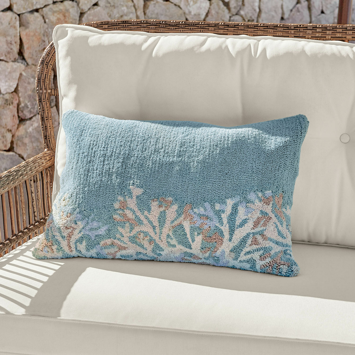 In- & Outdoorkissenhülle Dorlancourt Dekoratives Kissen aus weichem Material in Blau mit Korallenmotiv auf hellem Sofa.