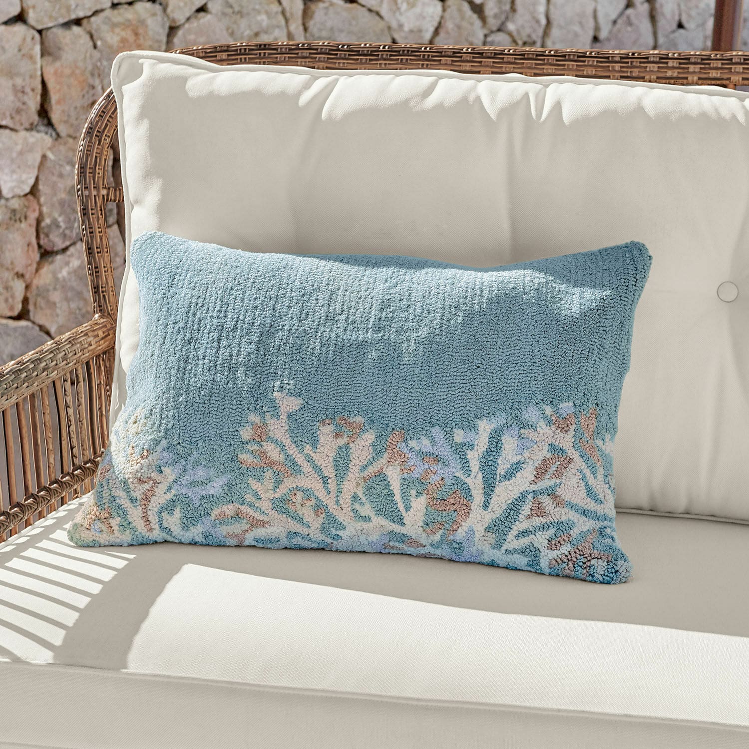 In- & Outdoorkissenhülle Dorlancourt Dekoratives Kissen aus weichem Material in Blau mit Korallenmotiv auf hellem Sofa.