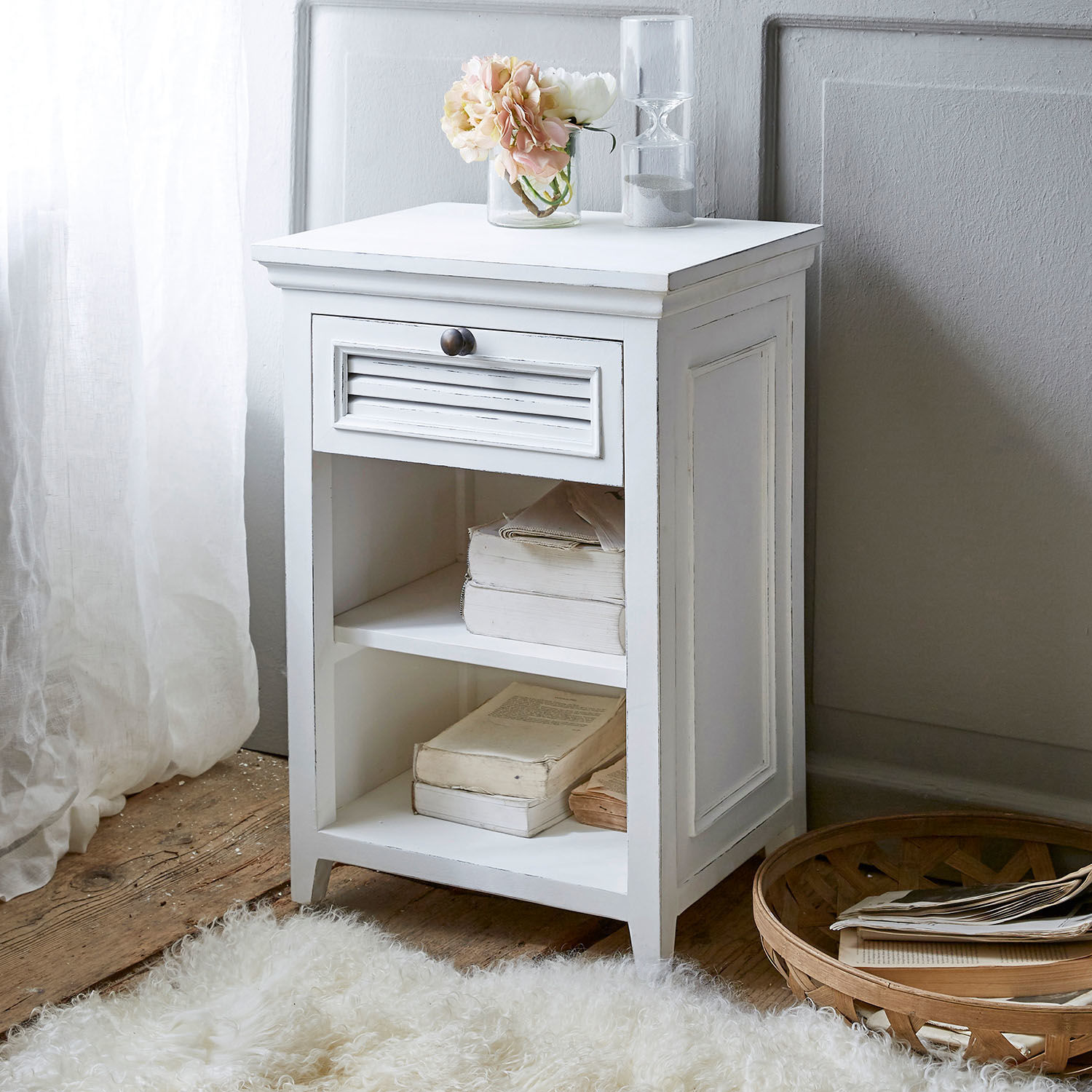 Nachttisch Williston Weißer Holz-Nachttisch mit Schublade und Regalen, dekoriert mit Blumen und Sanduhr