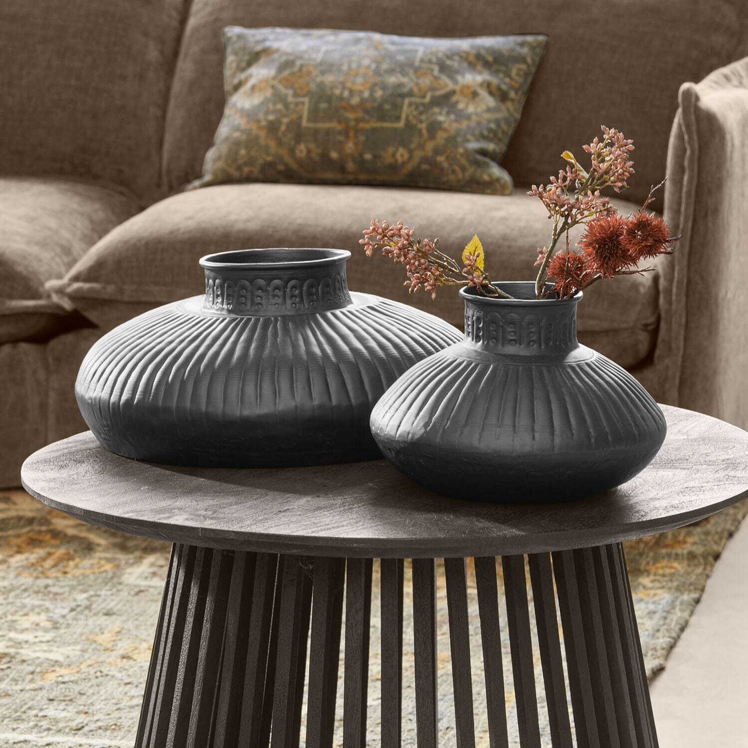 Vase 2er Set Myrkja Zwei schwarze Keramikvasen mit geriffeltem Muster auf einem Holztisch im Wohnzimmer