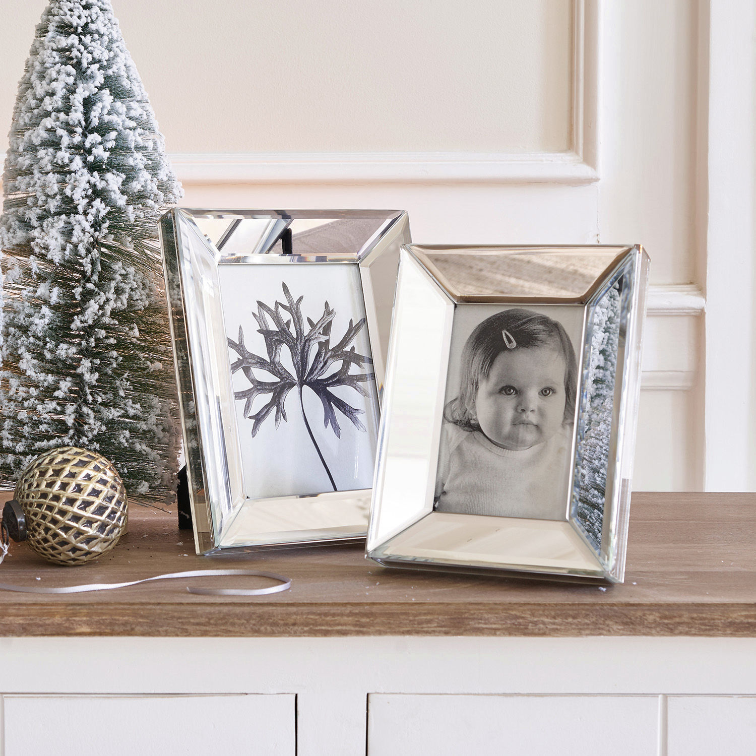 Bilderrahmen 2er Set Dominique Zwei verspiegelte Bilderrahmen auf Holzplatte mit Weihnachtsdeko und schneebedecktem Tannenbaum