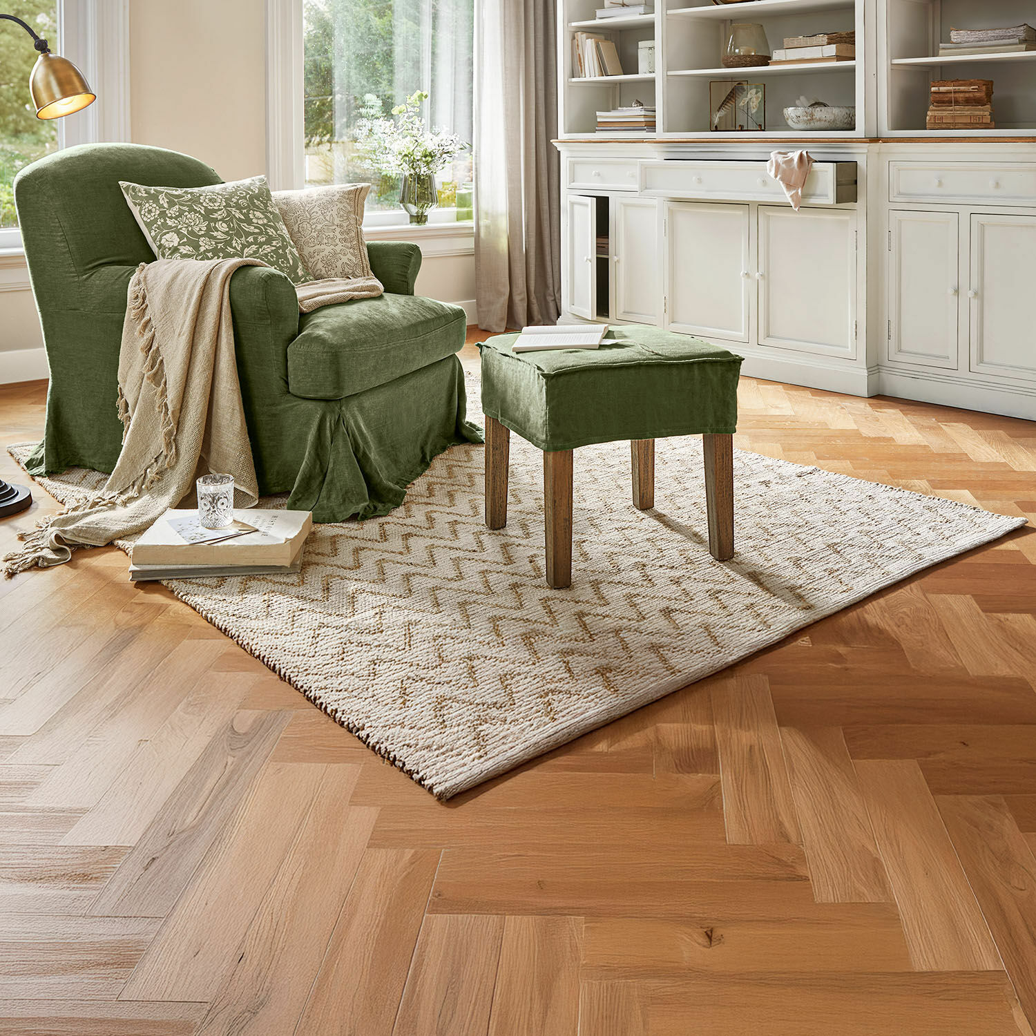 Wendeteppich Vendeline Grüner Polsterstuhl und Hocker aus Stoff in gemütlichem Wohnzimmer mit Teppich und Holzboden