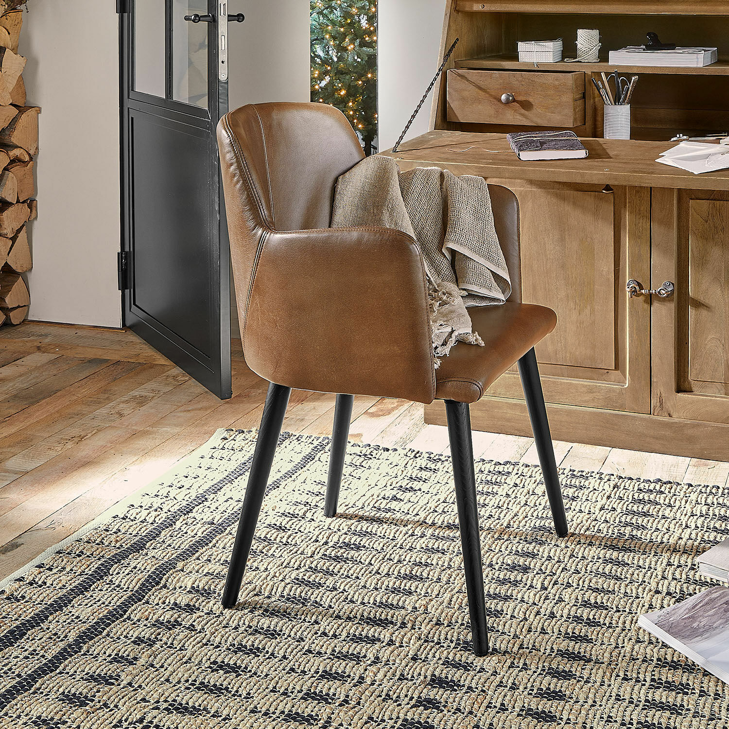 Brauner Stuhl aus Kunstleder mit schwarzen Beinen auf Teppich in gemütlichem Raum mit Holzmöbeln
