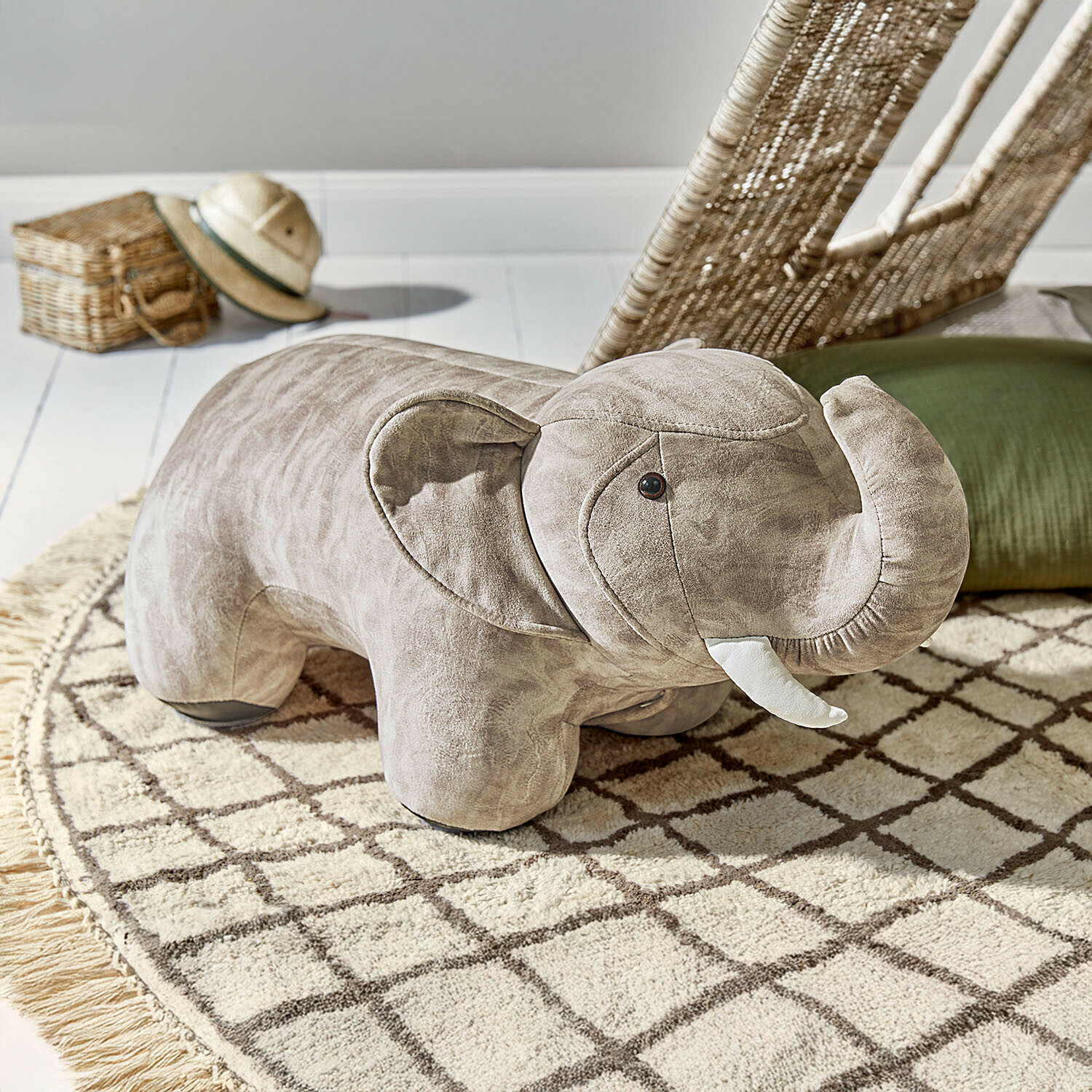 Sitztier Bellyboo Grauer Plüschhocker in Elefantenform auf gemustertem Teppich im Kinderzimmer