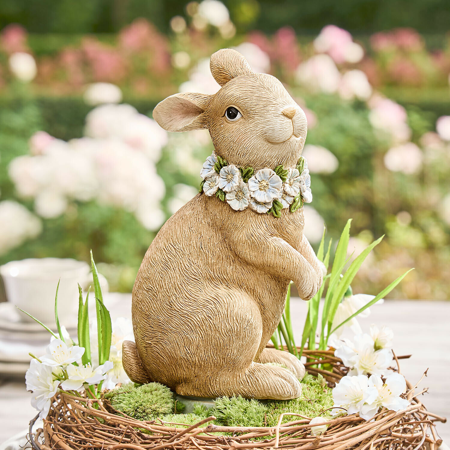 Beige Hasenfigur aus Kunststoff mit Blumenkranz am Hals, frühlingshafte Dekoration für Garten oder Tisch