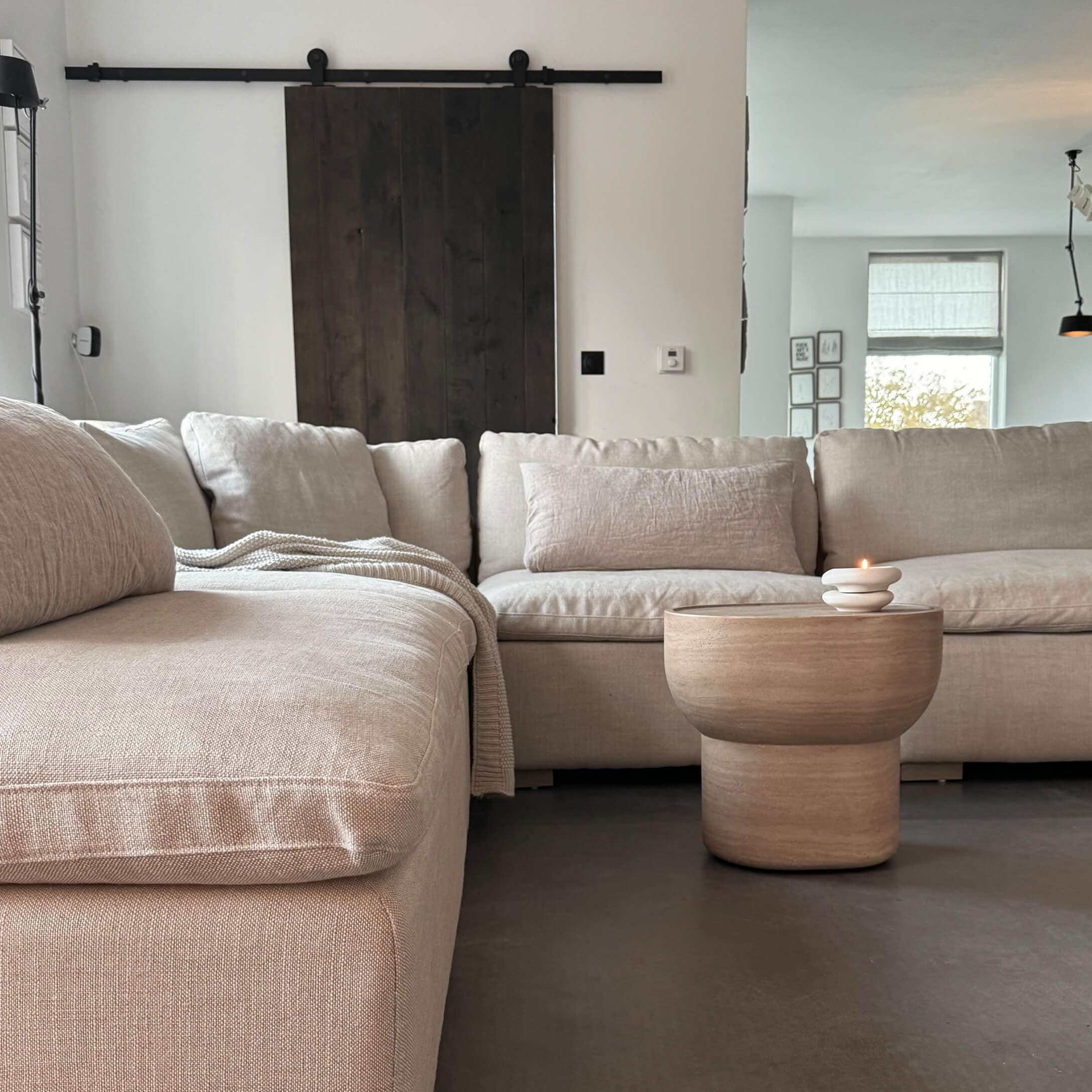 Beige Ecksofa aus Stoff mit Holz-Couchtisch und Kerze in modernem Wohnzimmer