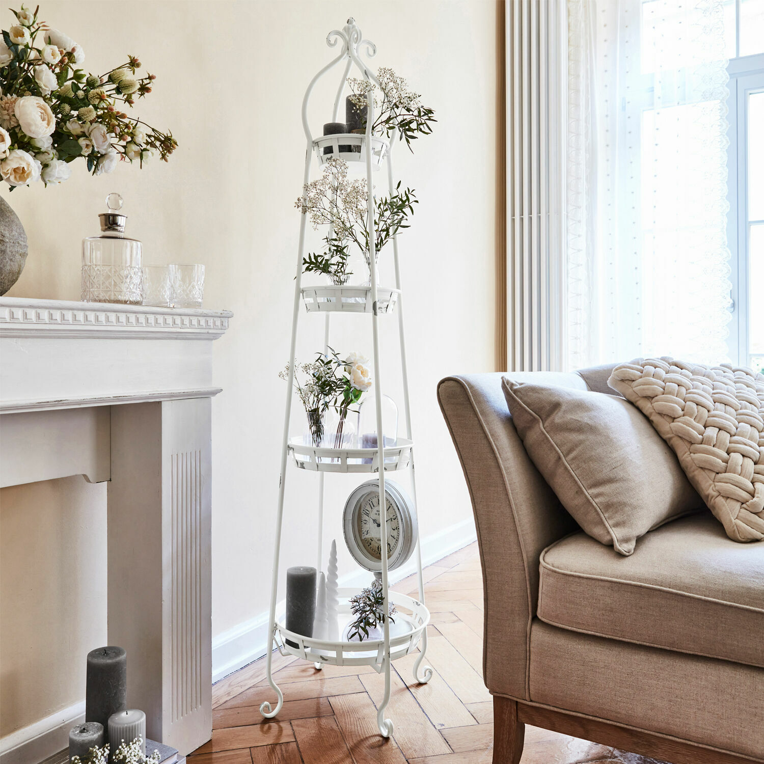 Etagere Ipas Weißes Metallregal mit Ablagen und Blumenarrangements im hellen Wohnzimmer mit beigem Sofa