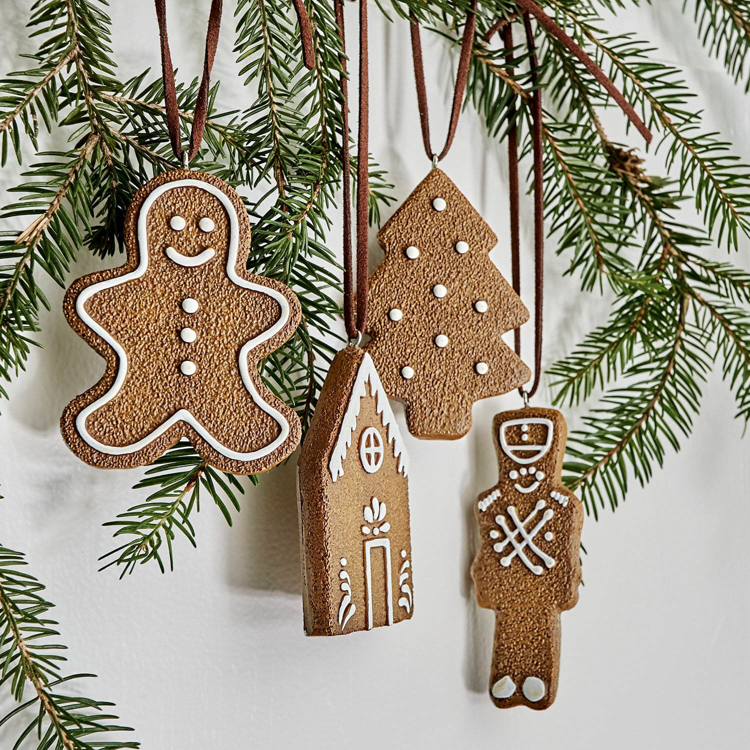 Anhänger 4er Set Nala Weihnachtsschmuck in Lebkuchenform aus braunem Material mit weißen Verzierungen an Tannenzweigen