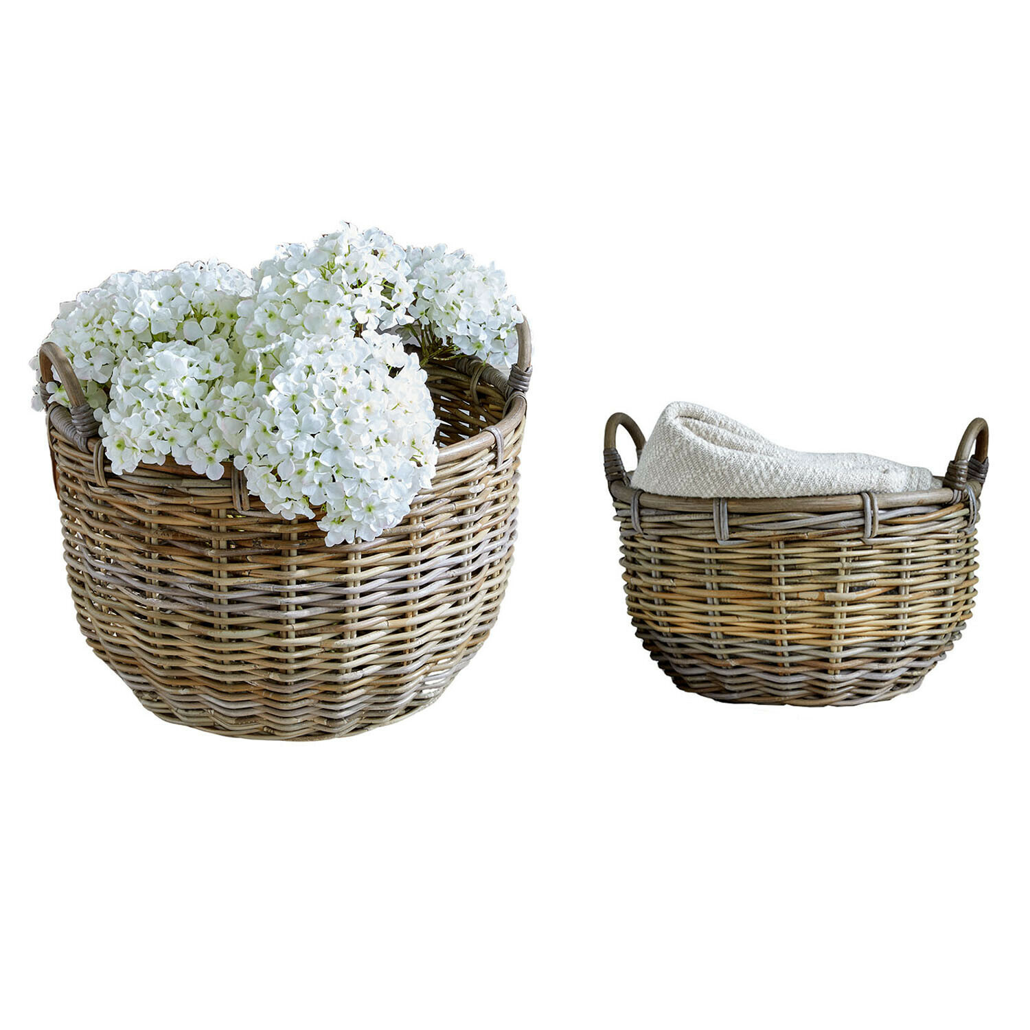 Set aus zwei naturfarbenen Weidenkörben, einer mit weißen Blumen, der andere mit Stoff gefüllt
