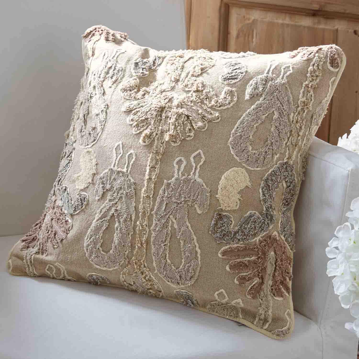 Beige Dekokissen mit pastellfarbenem Stickmuster auf weißem Sofa für Wohnraumgestaltung