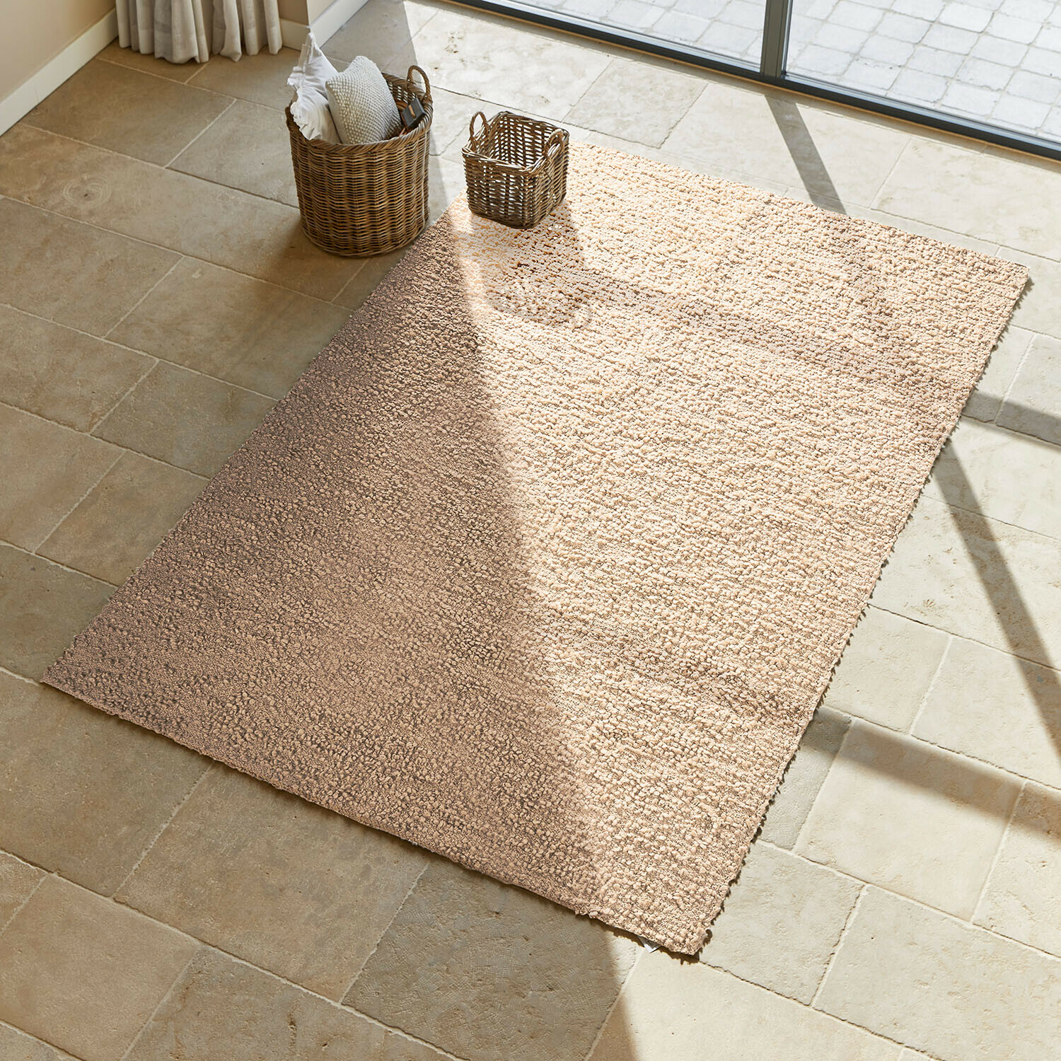 Teppich Wodaha Beiger Teppich aus weichem Material auf hellem Steinboden in sonnigem Raum