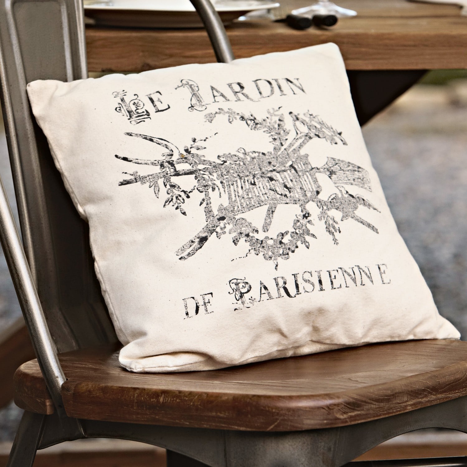Kissen Le jardin Beige Baumwoll-Dekokissen mit schwarzem Vintage-Druck auf rustikalem Holzstuhl