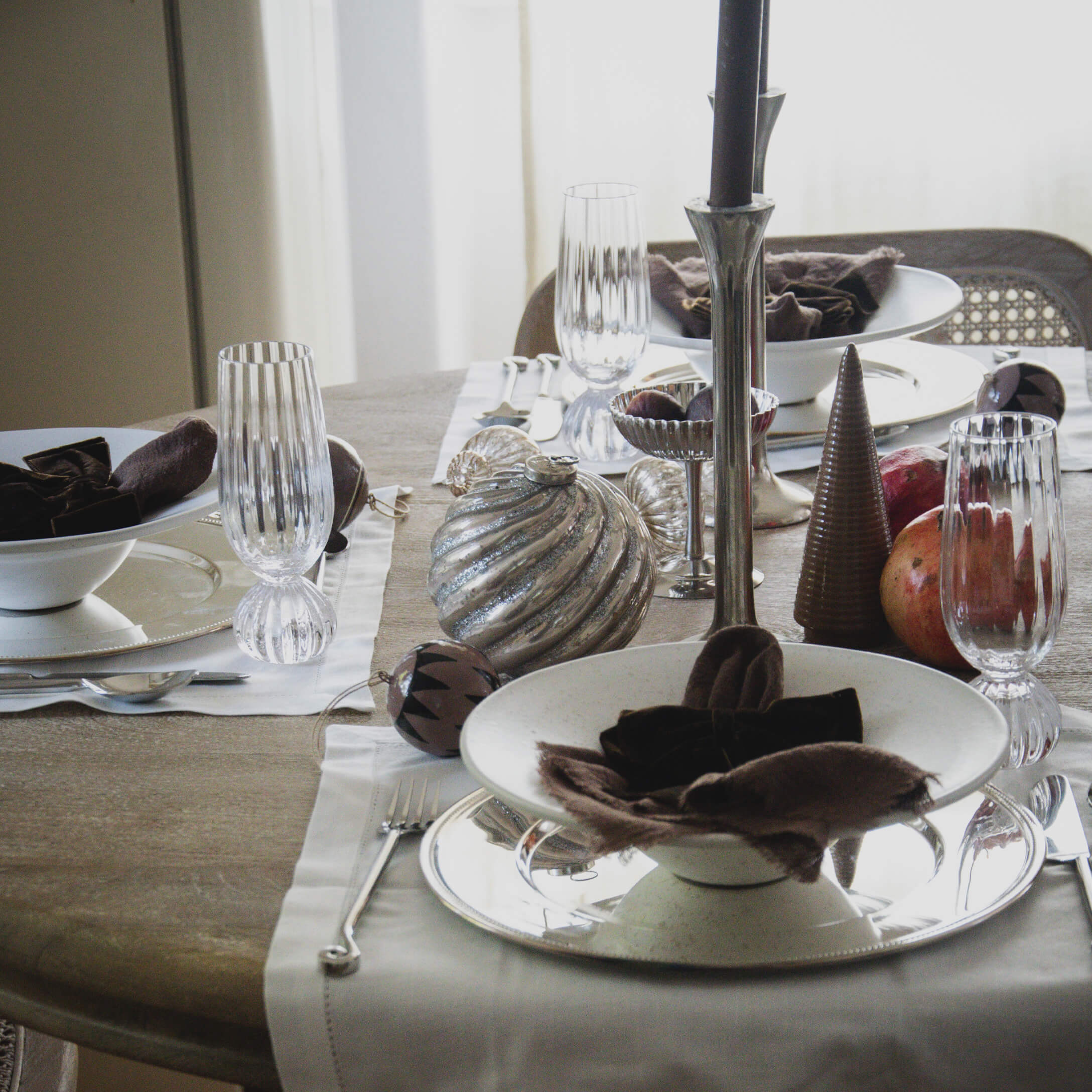 Eleganter gedeckter Tisch mit weißem Keramikgeschirr, Gläsern und natürlichen Dekorationen für festliches Essen