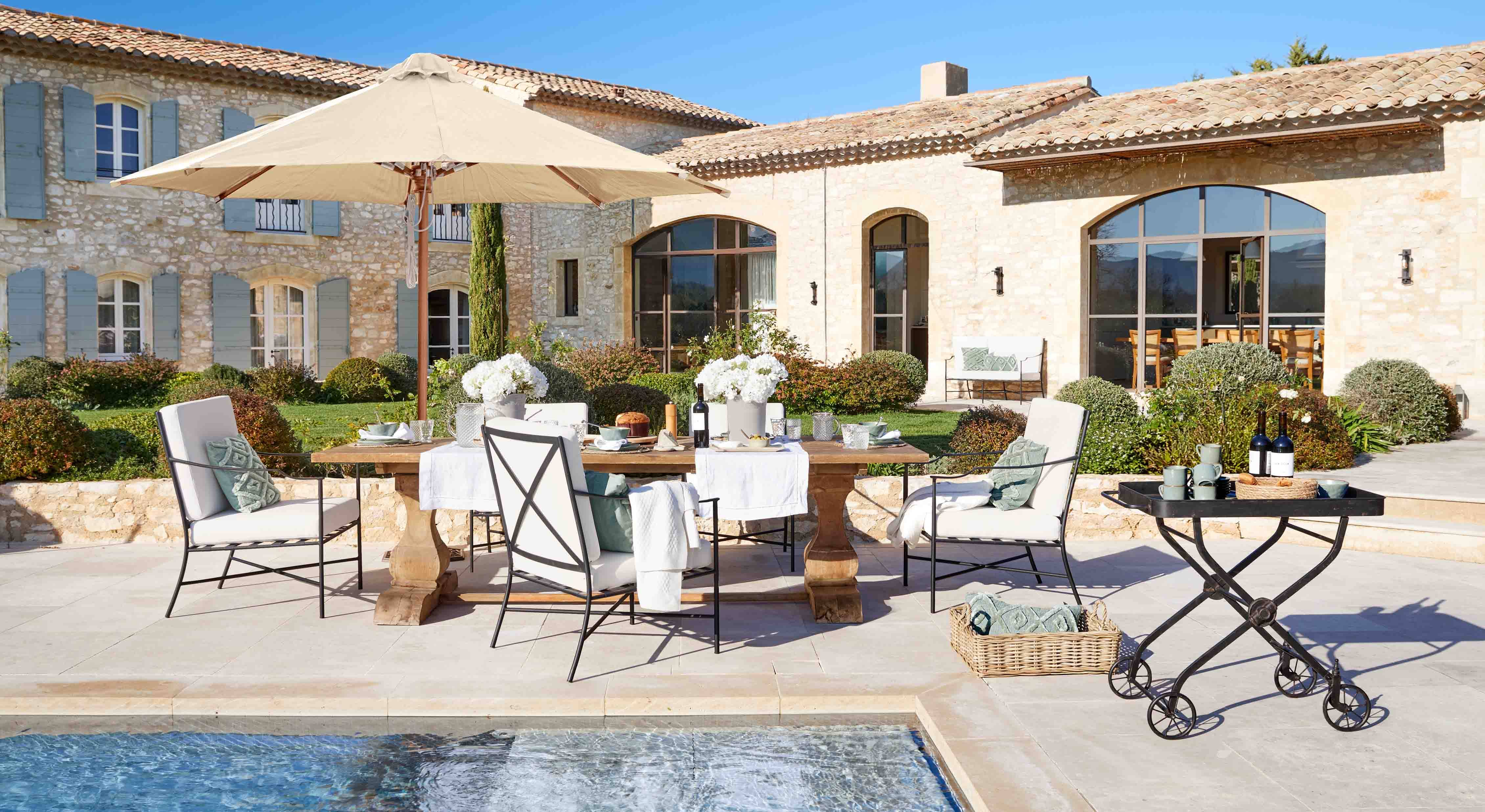 Elegantes Gartenmöbel-Set mit beigem Sonnenschirm und Holztisch am Poolbereich