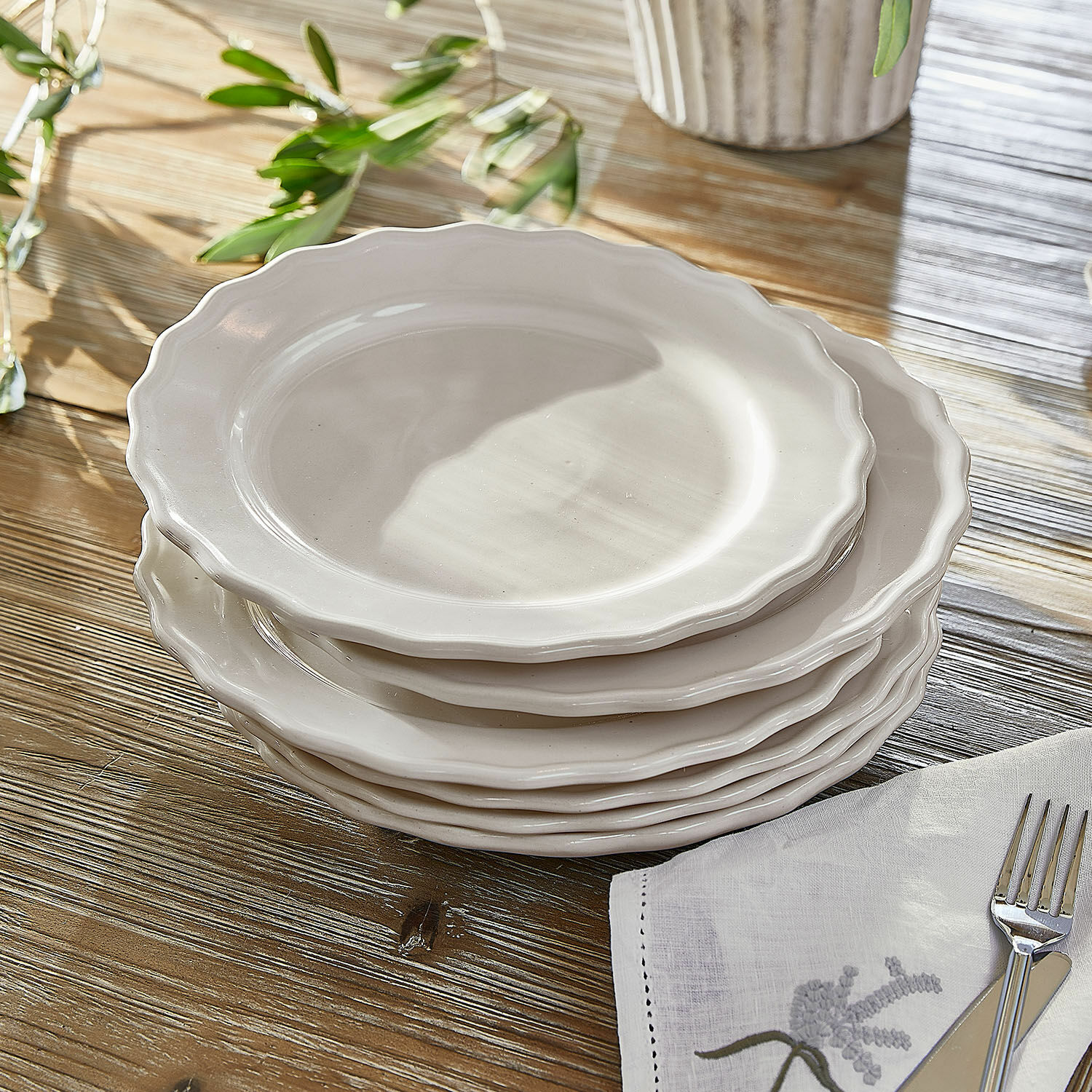 Teller 6er Set Mallevesse Set aus weißen Keramiktellern mit wellenförmigem Rand auf Holztisch mit Serviette und Besteck