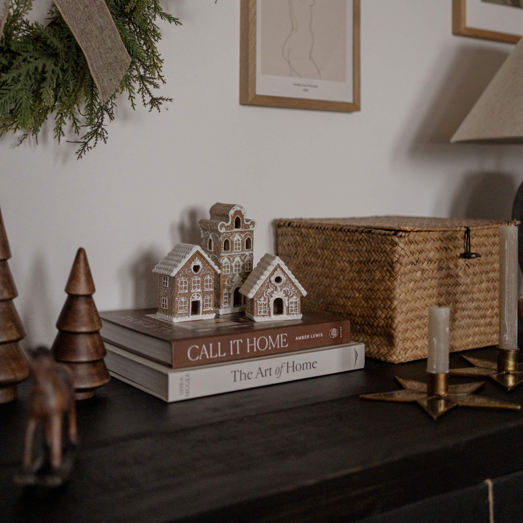 Dekorative Tonhäuser auf Büchern auf dunklem Tisch mit Naturdeko und Kerzen arrangiert