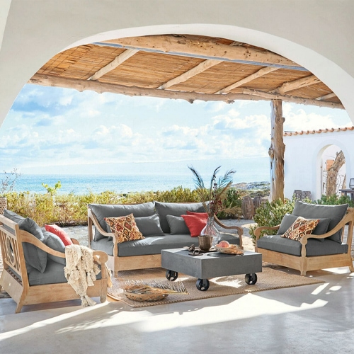 Gartenmöbel-Set aus Holz mit grauen Polstern auf Terrasse mit Meerblick, komfortable Lounge-Möbel