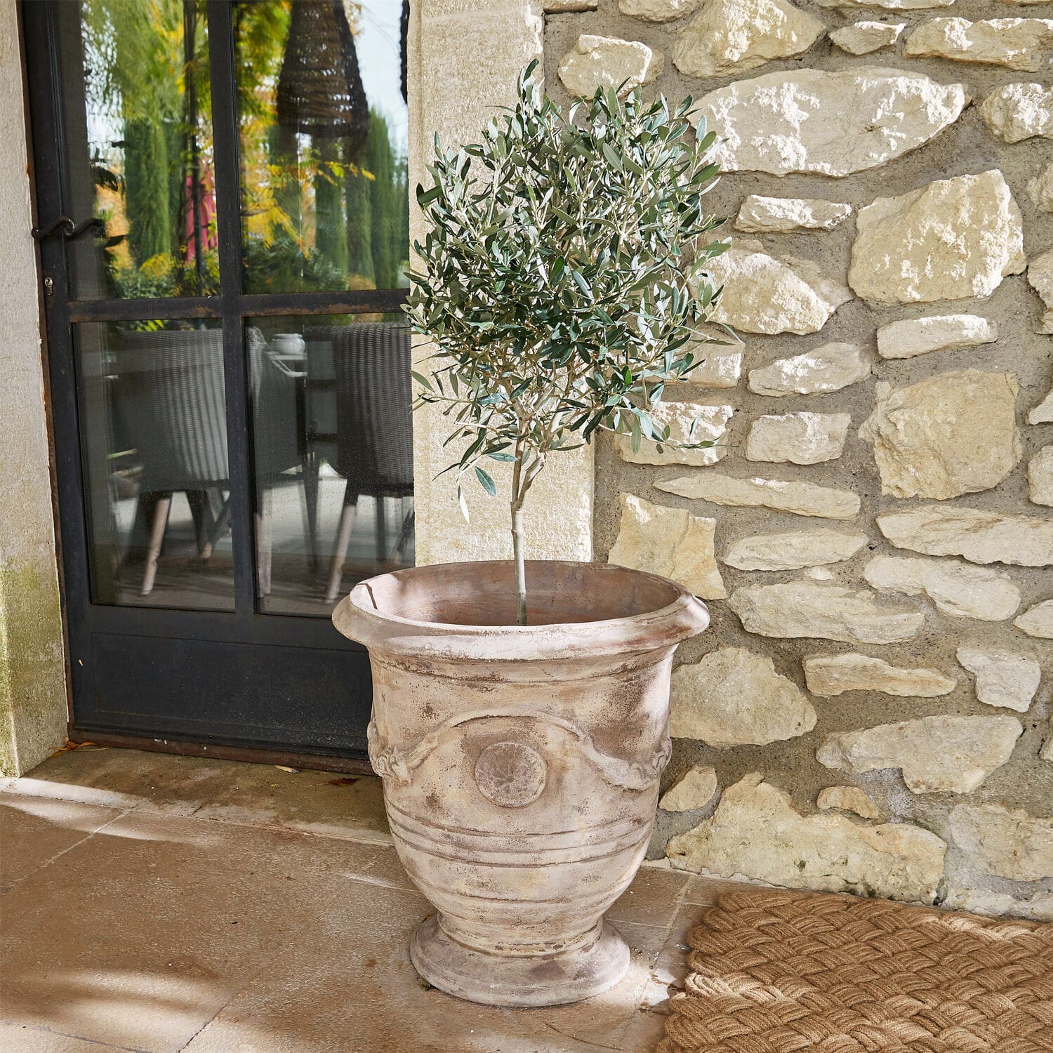 Übertopf Garwood Großer dekorativer Terrakotta-Blumentopf in Beige mit grüner Pflanze auf Terrasse