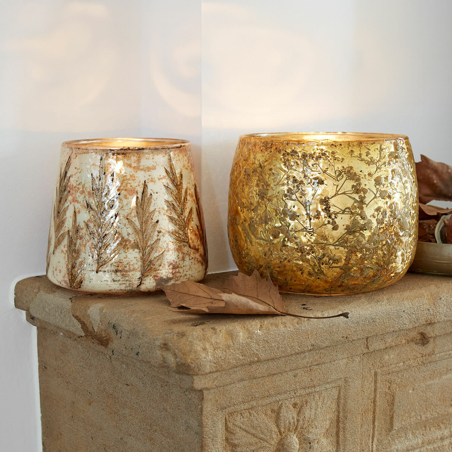 Windlicht 2er Set Hivalen Zwei dekorative Glaswindlichter mit Blattmotiv in Gold und Creme auf steinerner Ablage