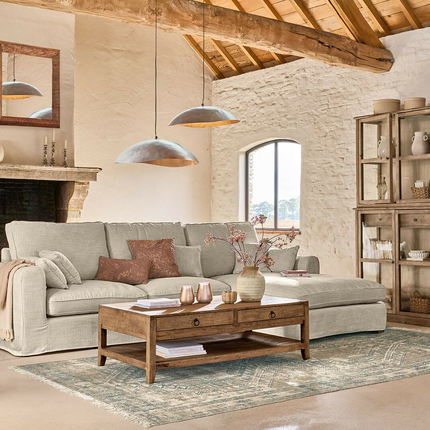 Gemütliches Wohnzimmer mit beigem Stoffsofa und Holzcouchtisch auf Vintage-Teppich