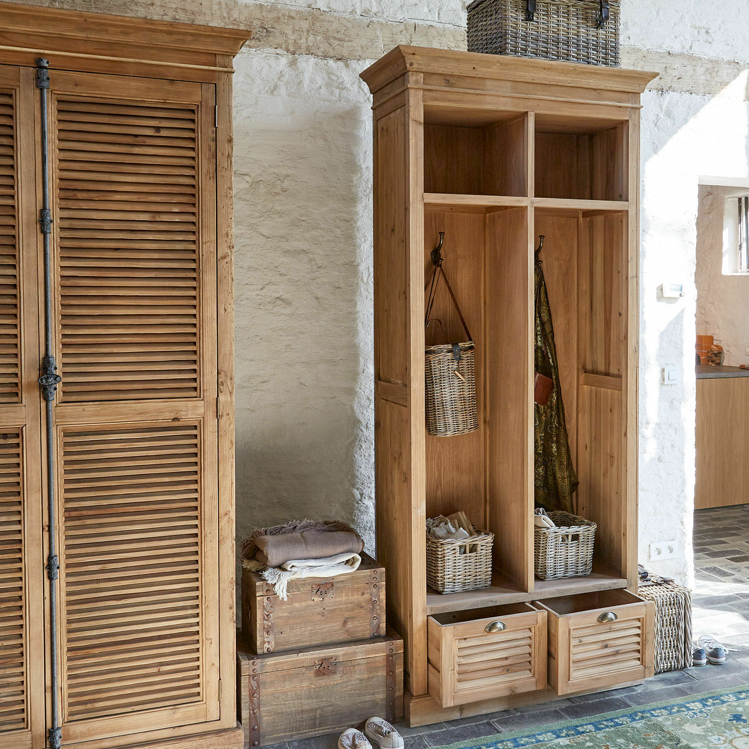 Garderobe Farnham Holzschrank und offene Garderobe mit Körben und Haken in hellem Raum mit Steinwand