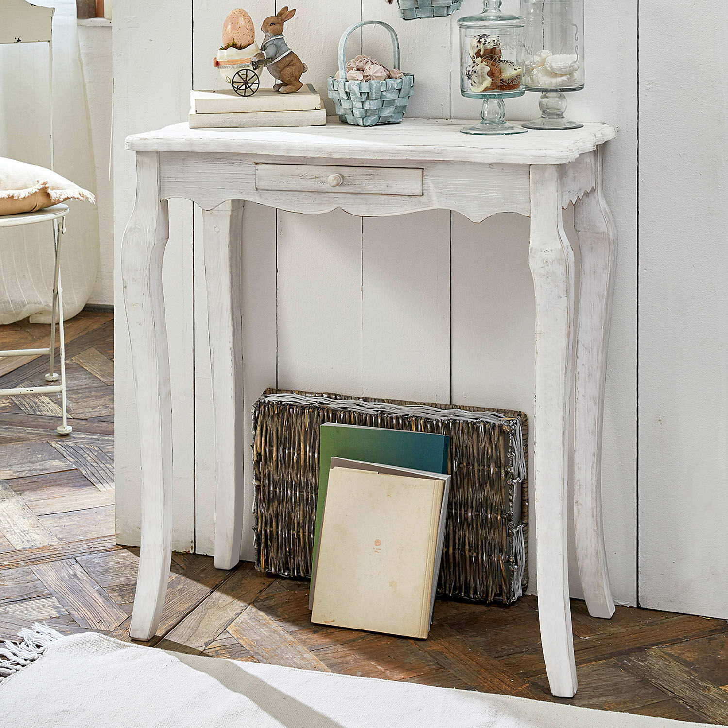 Weiße Holzkonsole im Vintage-Stil mit Schublade auf Holzboden mit Osterdekorationen