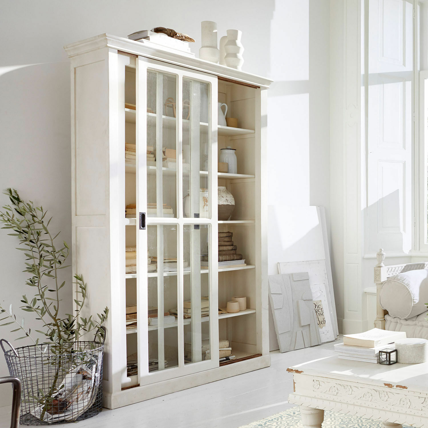 Schrank Brouns Weiße Holzvitrine mit Schiebetüren aus Glas in hellem, modernem Wohnzimmer