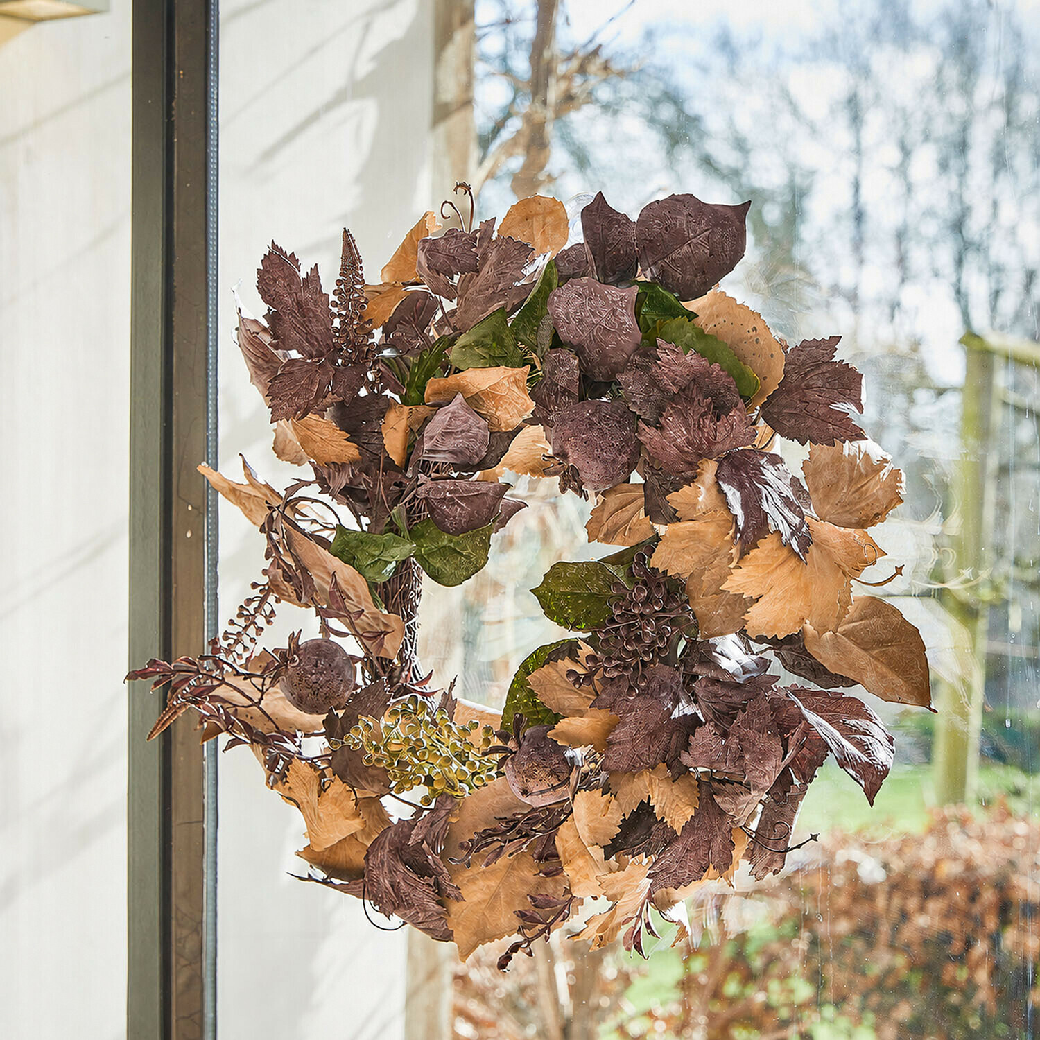Kranz Yvorie Esszimmer mit rundem Holztisch und Rattanstühlen mit weißen Polstern und herbstlicher Dekoration